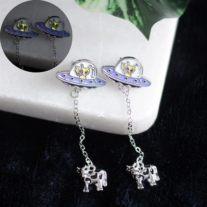 Glow-in-the-dark UFO dangle earrings with silver alien charms by Noctis Occult.