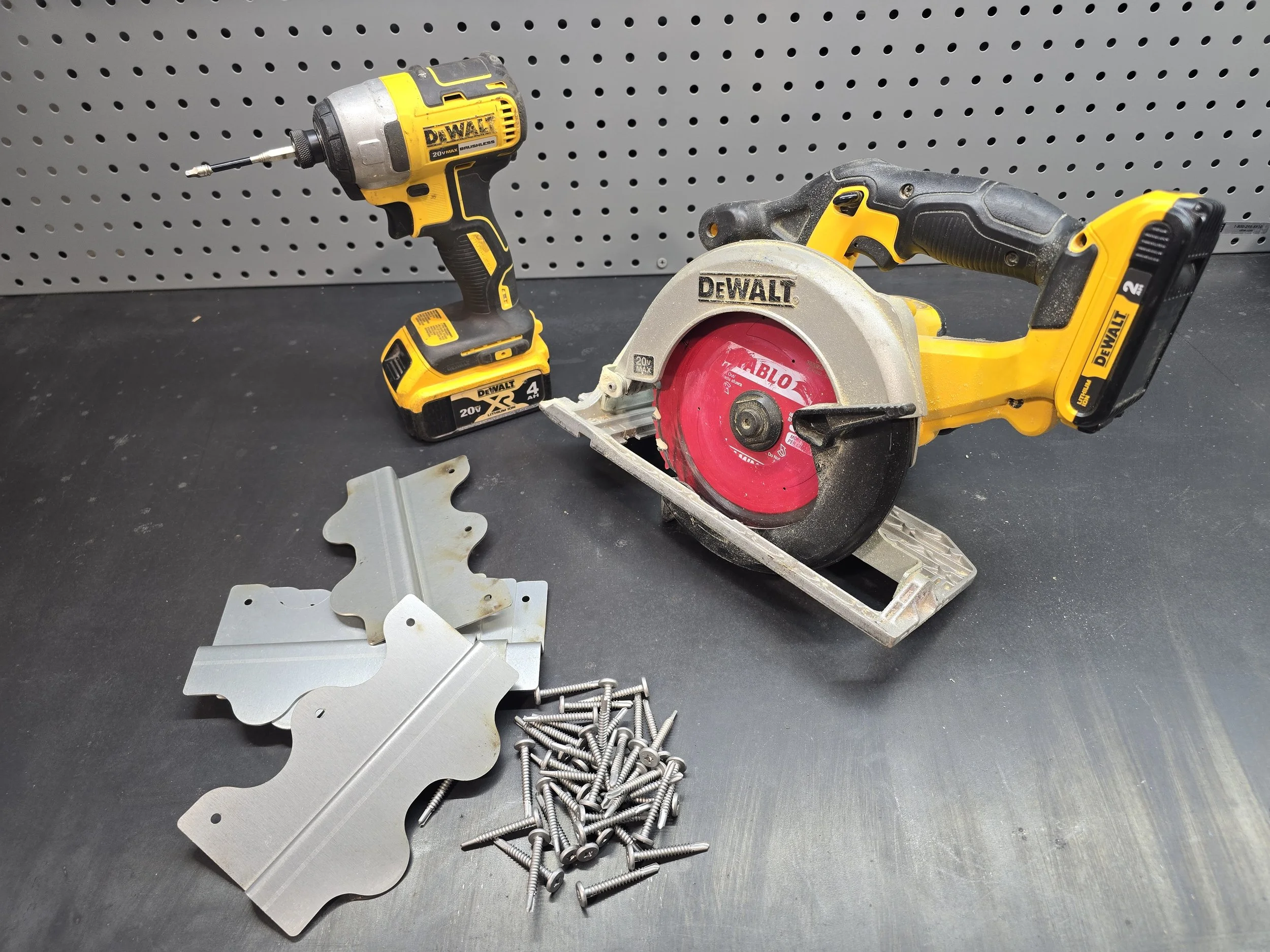 Buckle Down roofing cleats with installation tools including impact driver, circular saw, and roofing screws used for reinforcing roof decking seams during metal roofing projects
