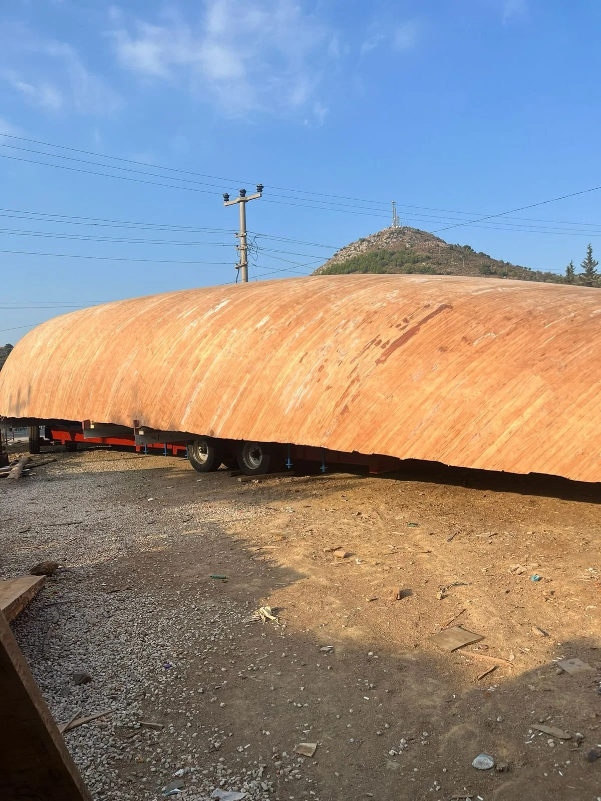 The hull on its trailer being moved to the fitting out area