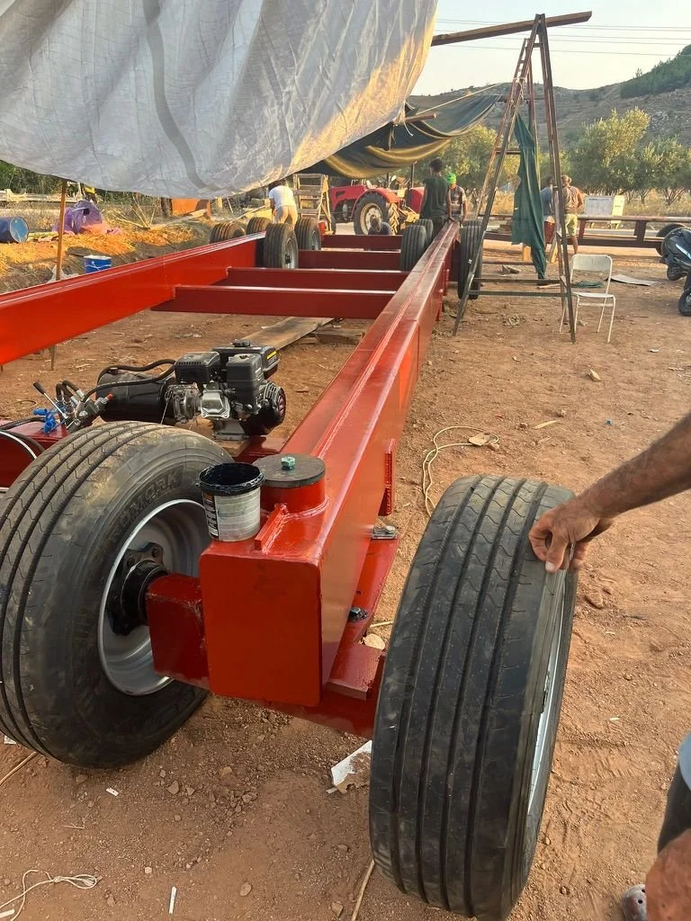 The 12 wheel trailer with hydraulic steering is readied to take completed hull from assembly shed