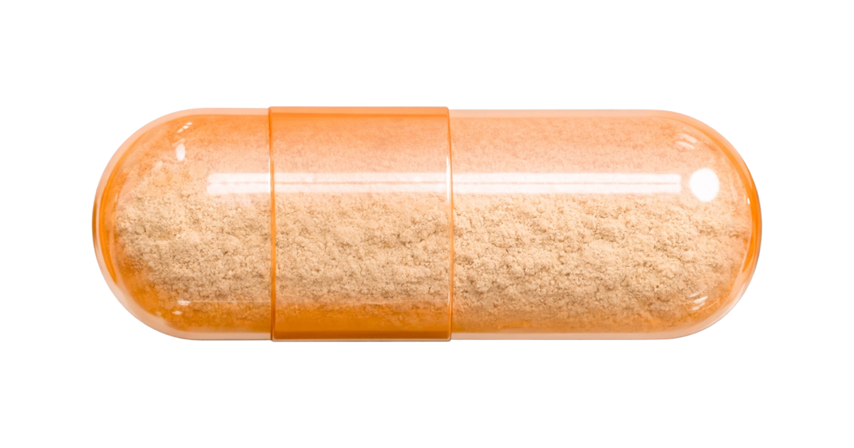 An orange capsule pill filled with a beige powder, lying on a black background.