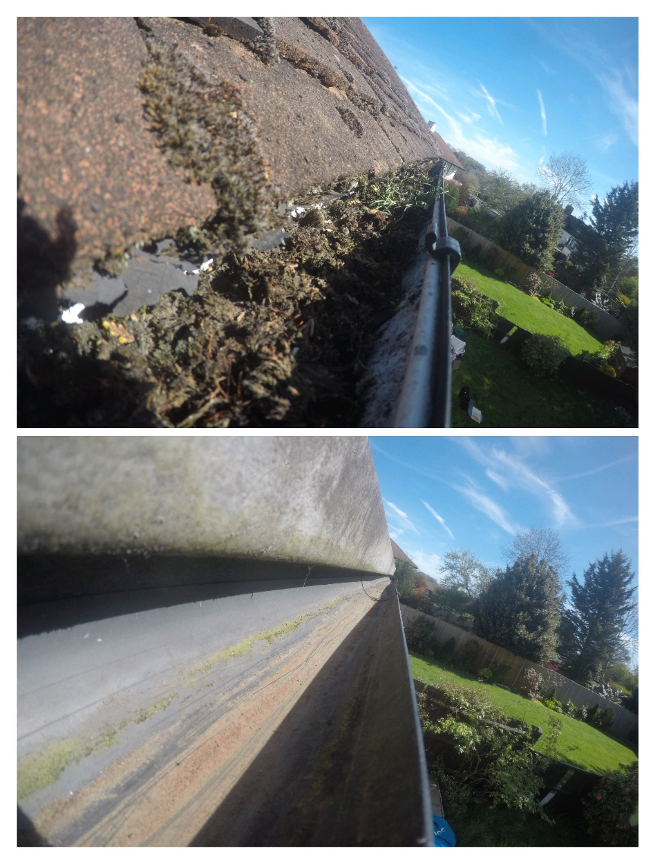 Close-up of a house roof with a gutter filled with dirt, leaves, and debris, under a blue sky with wispy clouds and trees in the background.