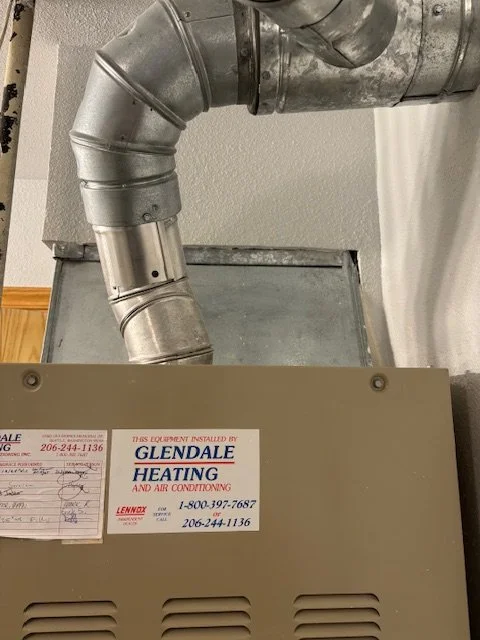 Close-up of HVAC equipment with metallic ductwork connected at the top and a label from Glendale Heating and Air Conditioning