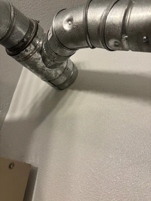 Metal industrial pipes attached to a wall.