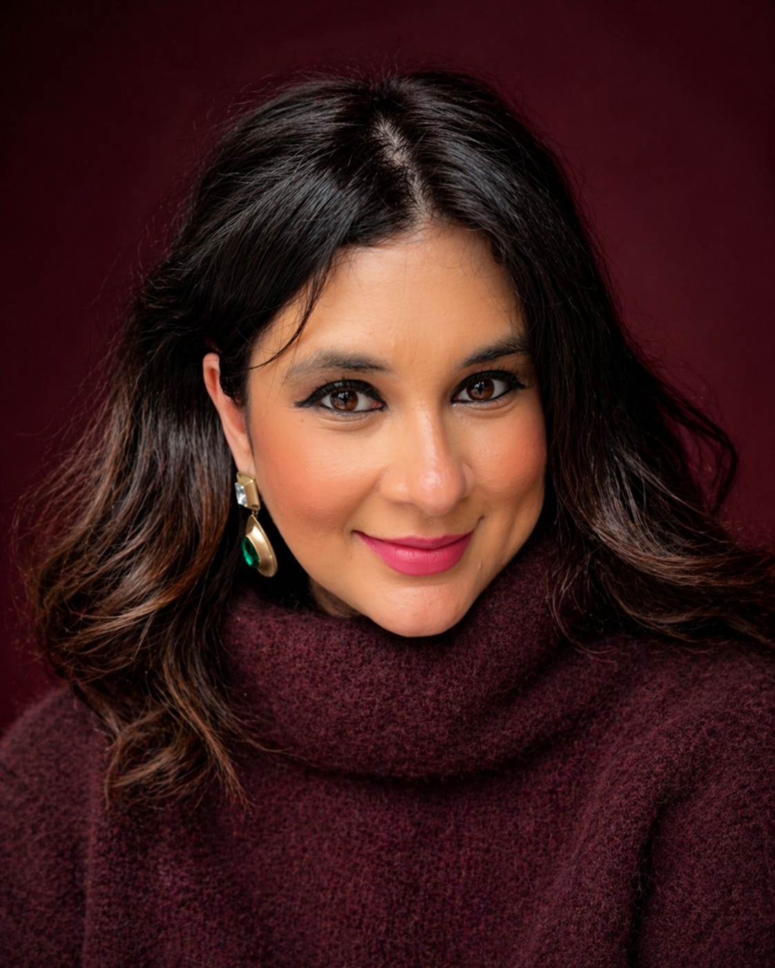 Natalia, founder of Astromap Voyages, smiling in a mulberry knit — astrocartography and astrology travel expert