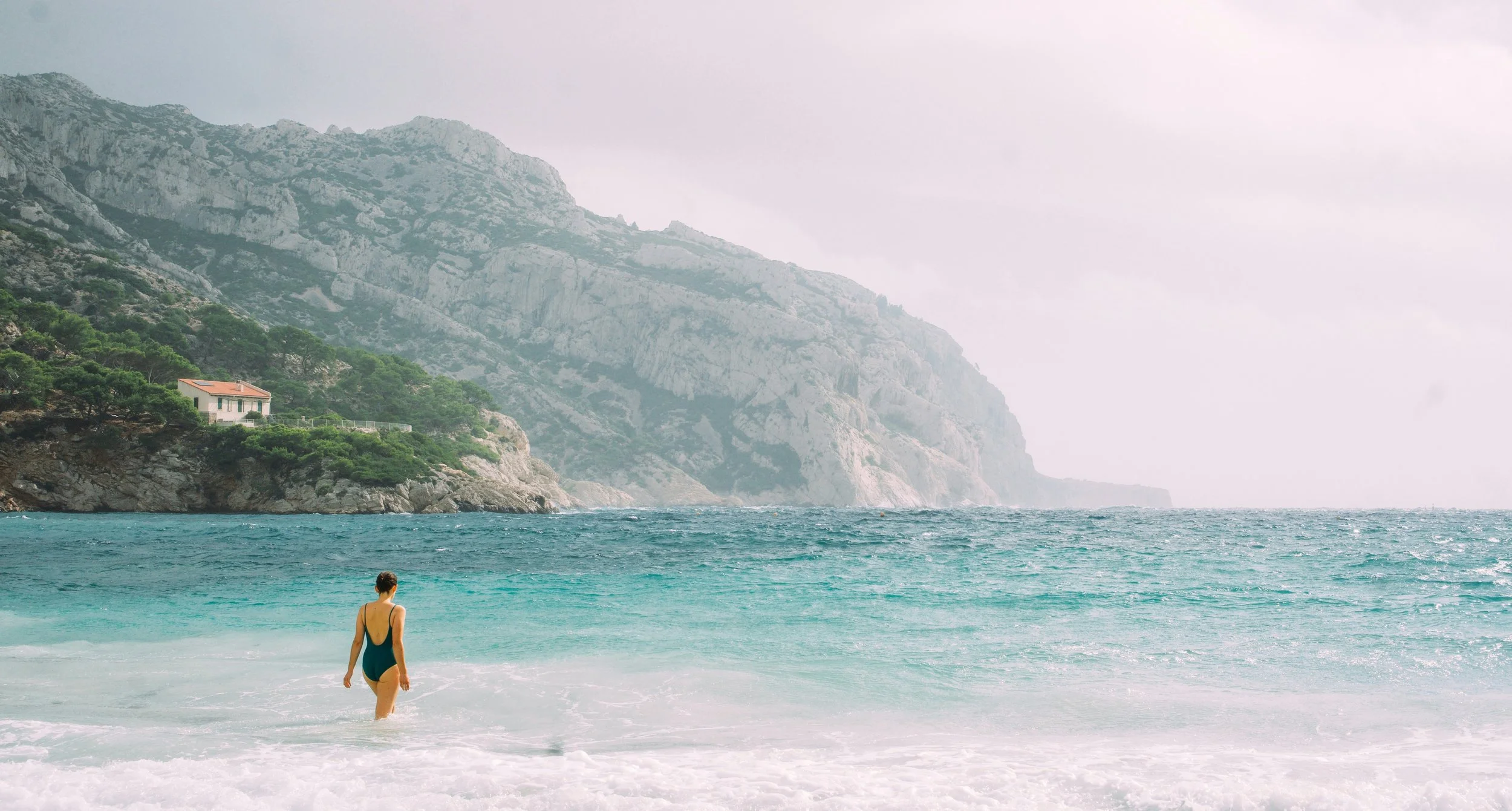 A woman swimming in the calanques in Marseille and Cassis, wellness retreats in Provence at the sea.