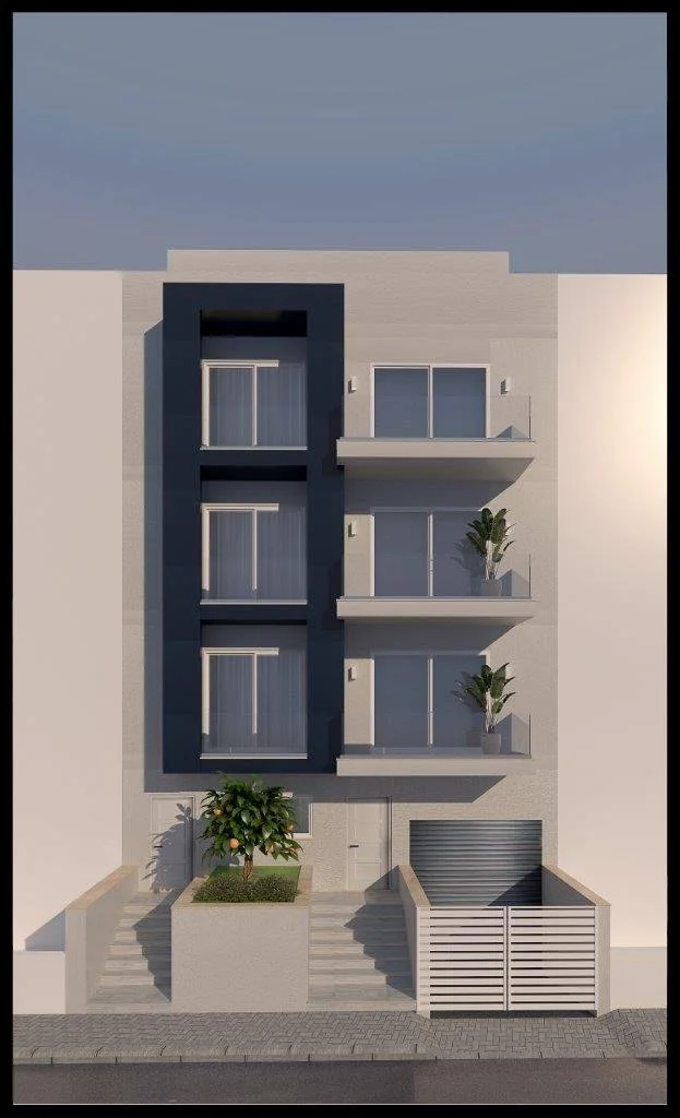 Modern multi-story apartment building with balconies, potted plants, and a small garden with a tree at the entrance, located on a city street.