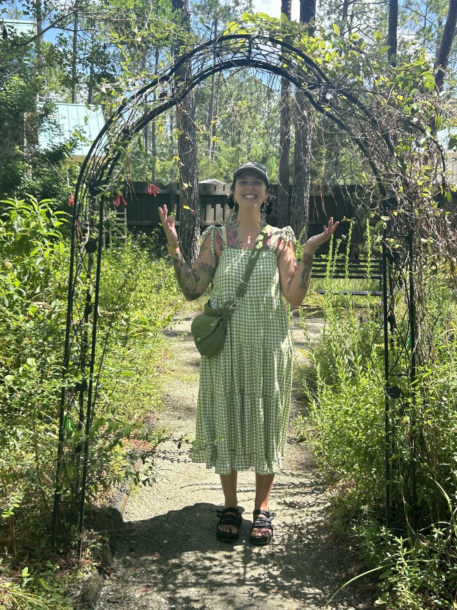 Photo of woman in garden archway smiling
