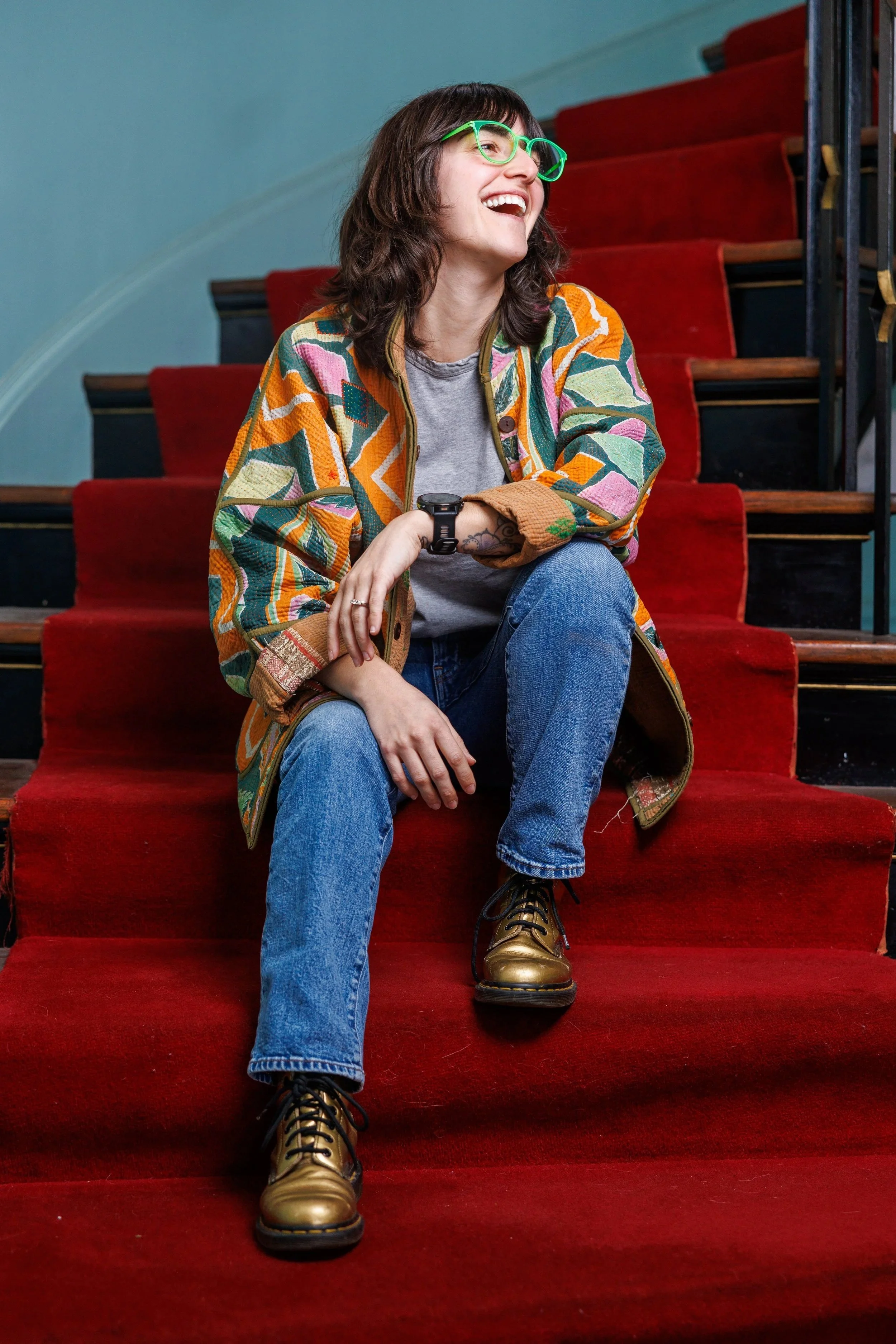 Andrea Belanger Rhode Island real estate agent and broker associate sitting on staircase in a historic building in Providence