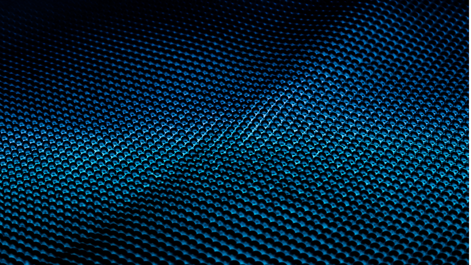 Close-up view of a textured surface with a pattern of small, shiny, blue spheres arranged in a grid.