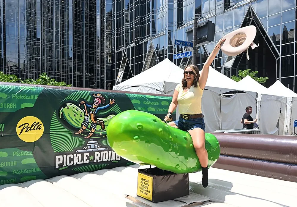 Picklesburgh - woman riding mechanical pickle - sponsored by Pella