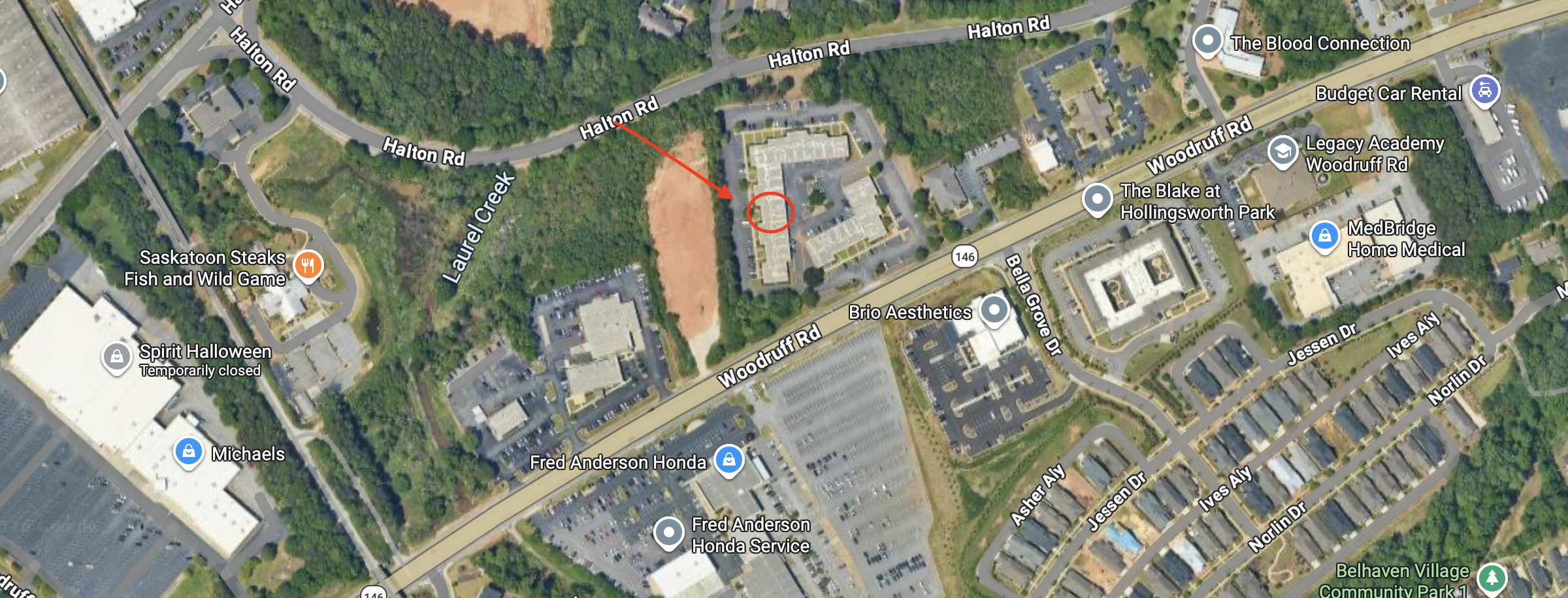 Satellite map view of a commercial and residential area showing streets, parking lots, buildings, and green spaces with a marked location on Halton Road near Laurel Creek Park.