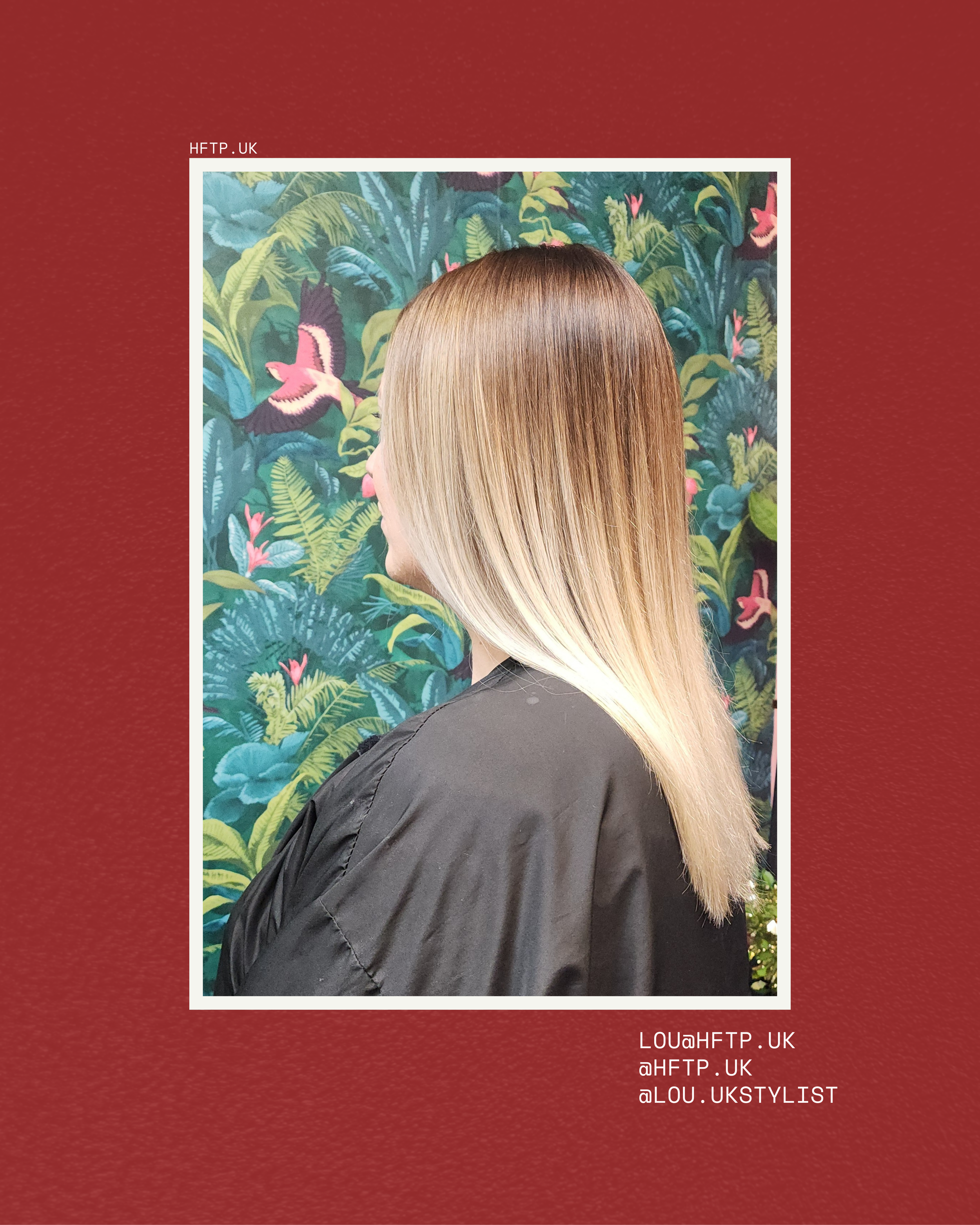 Profile view of a woman with straight blonde hair wearing a black jacket, standing in front of a decorative wall with a tropical or jungle theme featuring birds and lush plants.