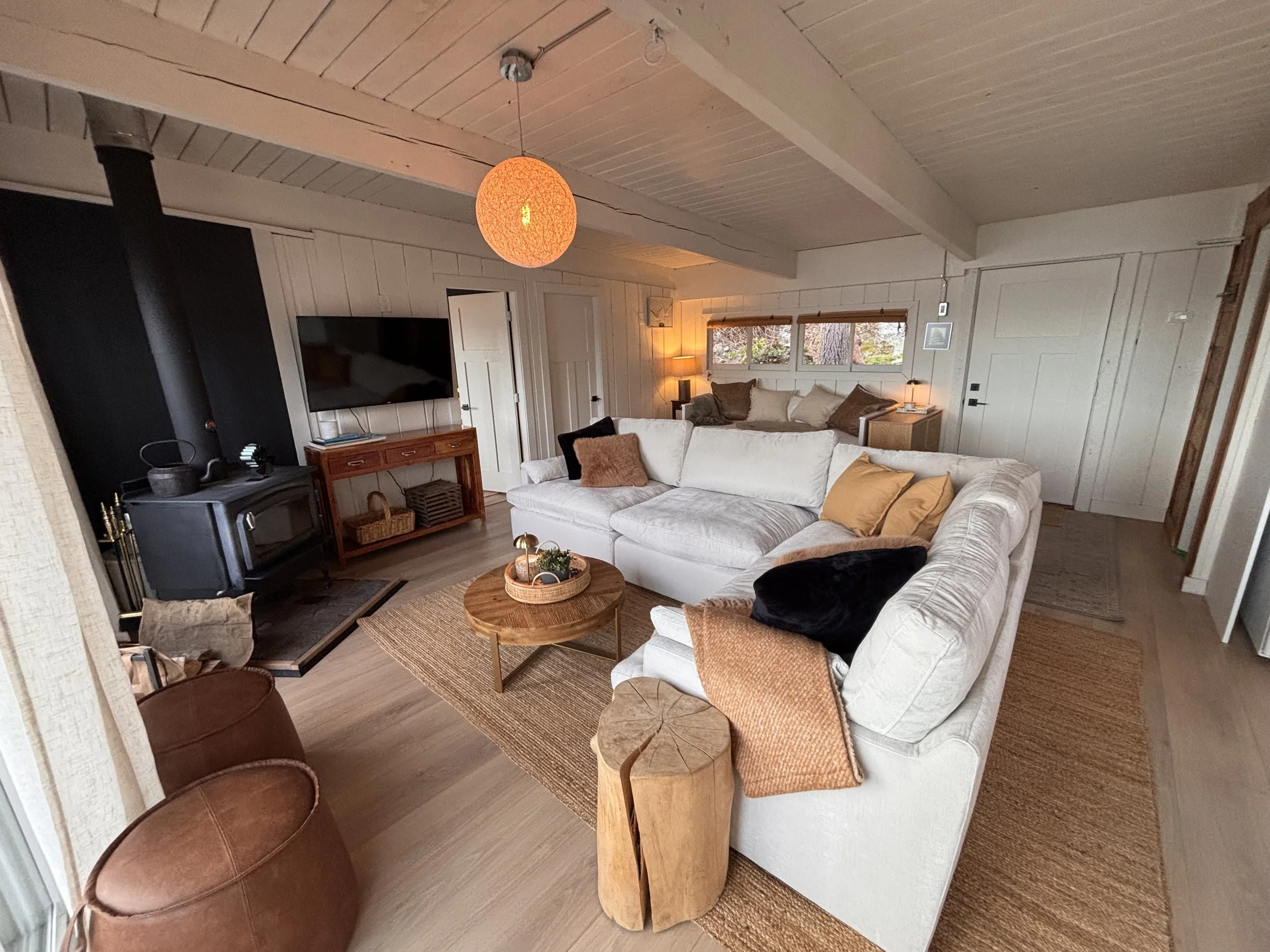 SALT cabin living room features a wood stove for nippy mornings and cozy nights, and a Smart TV. 