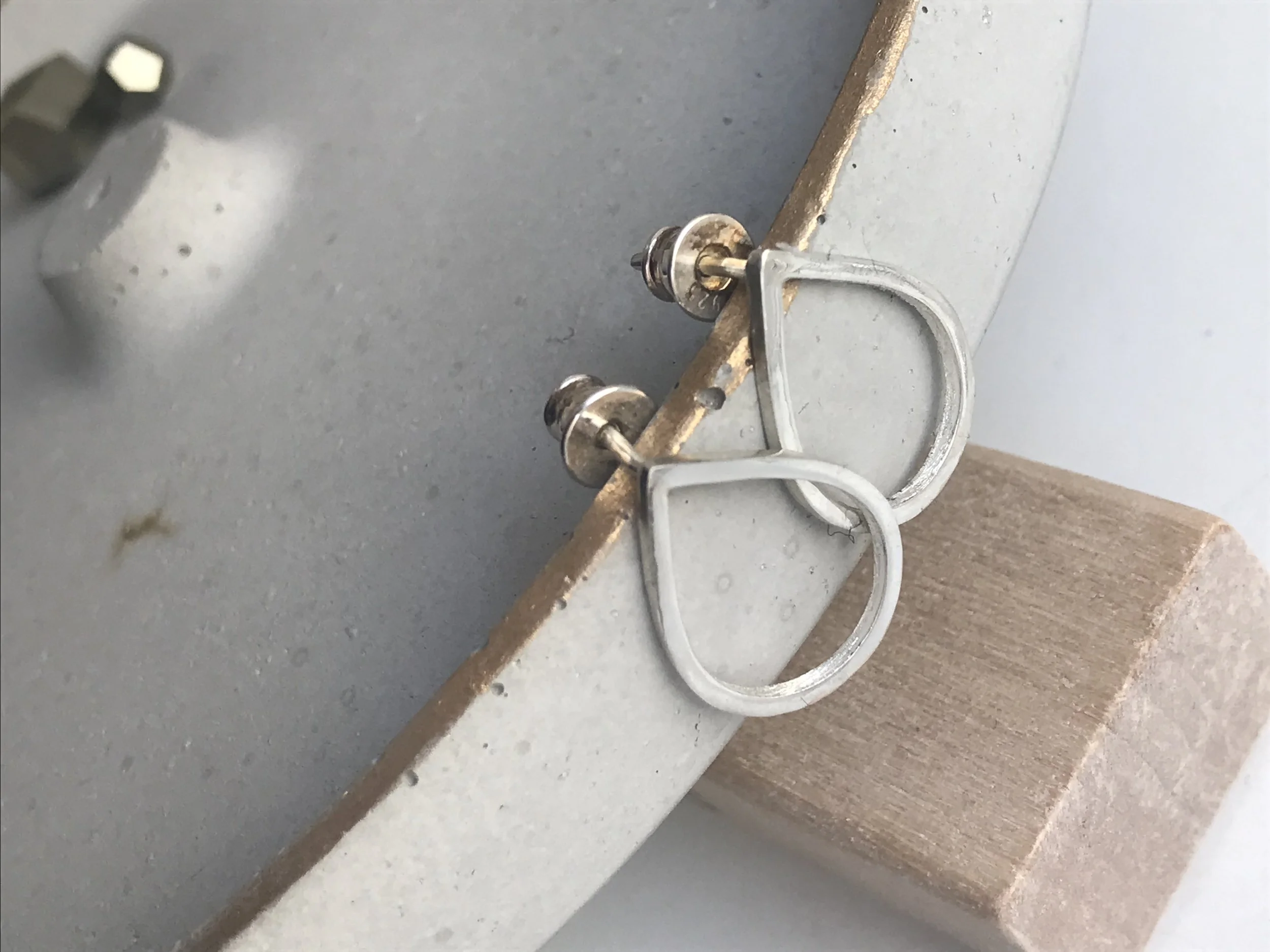 Close-up of a metallic latch or lock mechanism attached to a piece of wood.