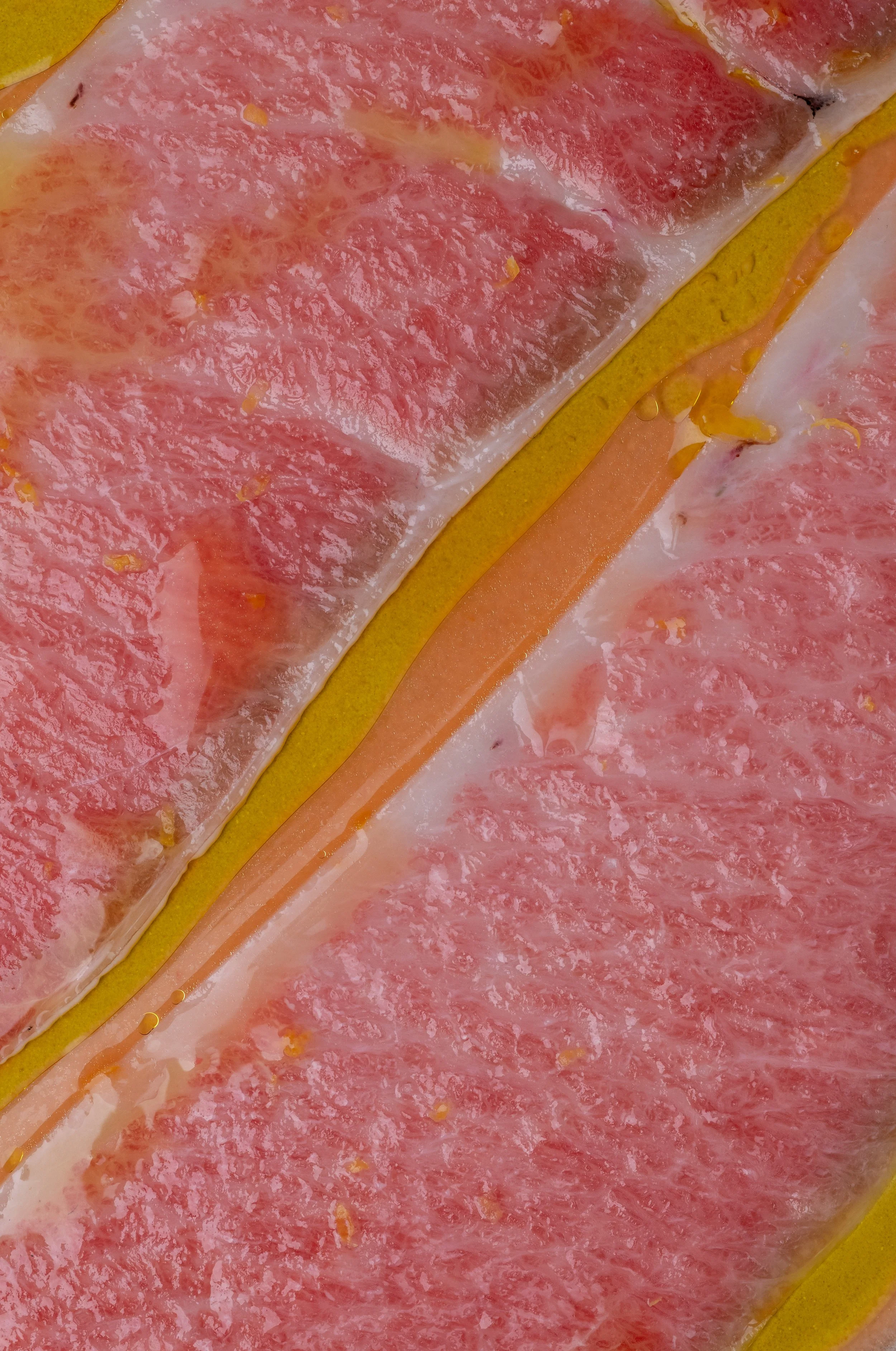 Close-up of sliced pink grapefruit with juicy flesh and thin white pith.