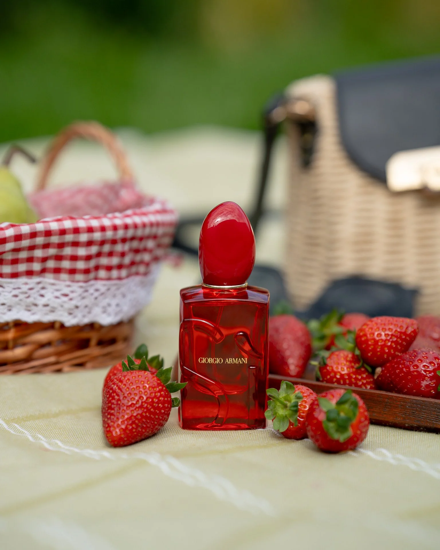 Giorgio Armani Si Red Musk surrounded and strawberries in picnic setting