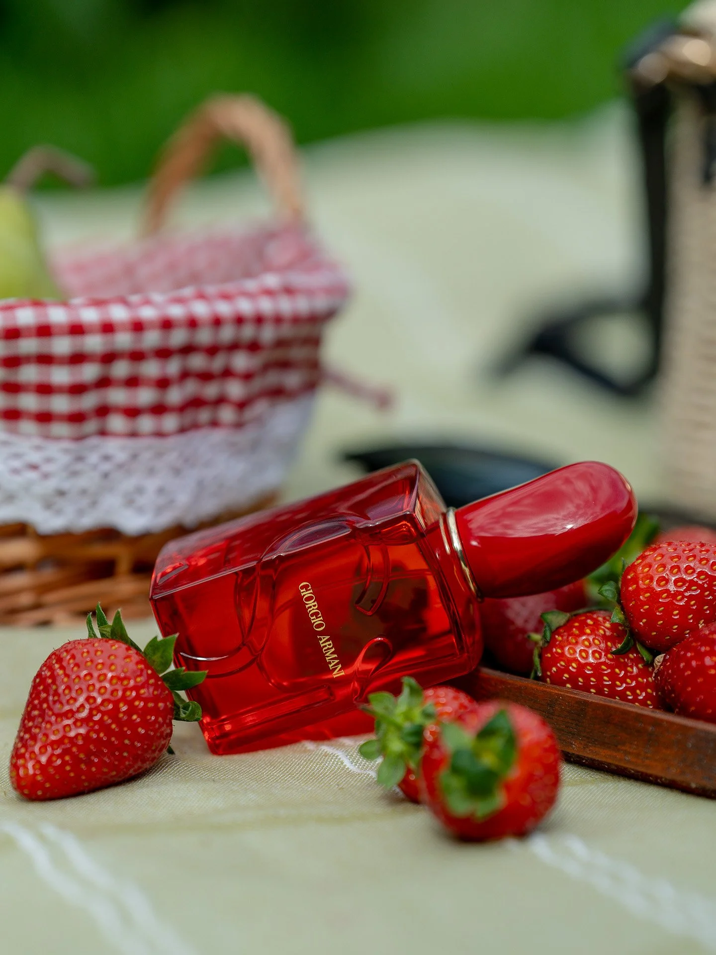Giorgio Armani Si Red Musk surrounded and strawberries in picnic setting