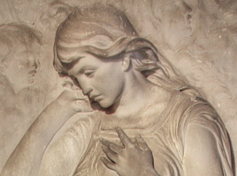 Sculpture of a woman with long hair, with two children in the background, one resting their head on her shoulder. St. Anne's church Oxenhall.