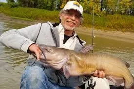 Professional angler Ted Ellenbecker holding a massive trophy flathead catfish.