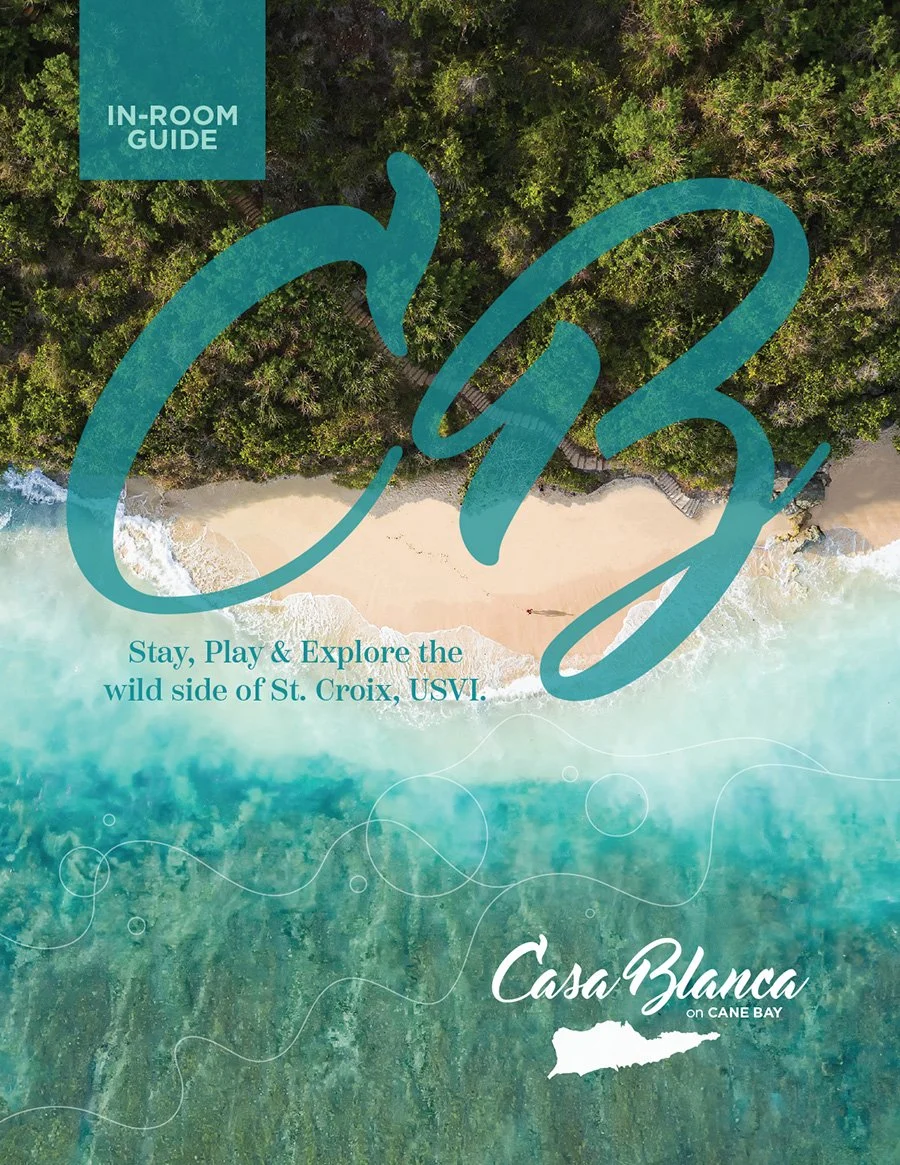 An aerial view of a beach with turquoise water meeting a sandy shoreline, backed by dense green forest, overlaid with the words 'In-Room Guide,' 'Stay, Play & Explore the wild side of St. Croix, USVI,' and the Casa Blanca on Cane Bay logo.