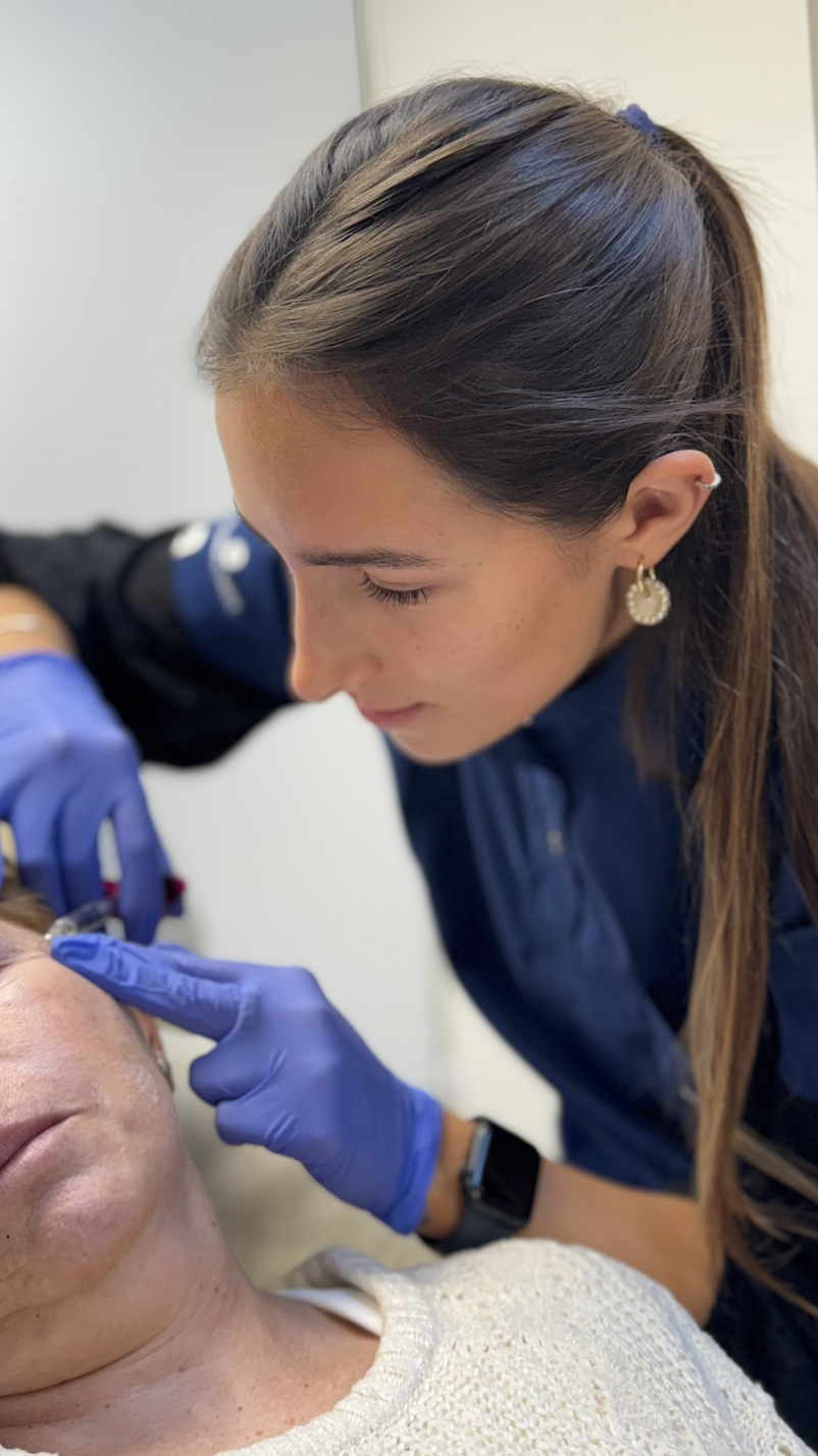 Doctora Maite Alvarez especialista en medicina estética, en Studio Maite Alvarez aplicando un tratamiento en región periocular a una paciente de edad media, tratamiento indoloro.