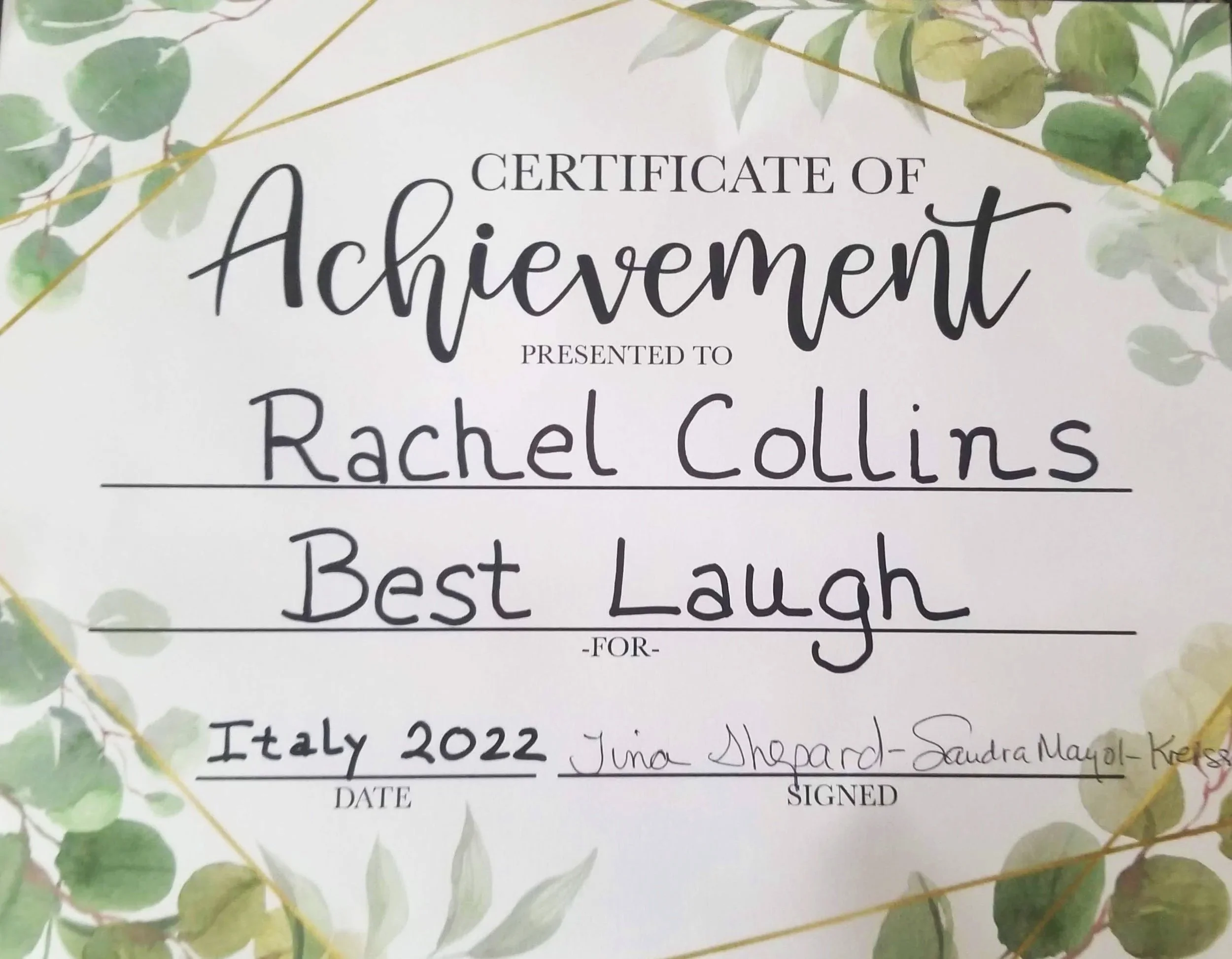 A certificate of achievement with a leaf design border, awarded to Rachel Collins for Italy 2022, signed by Juna Shepard and Sandra Magoll-Keith.
