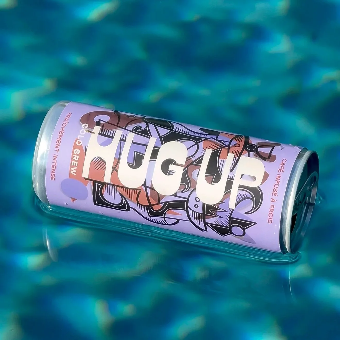 Une canette colorée flottant dans une piscine avec de l'eau bleue en arrière-plan.