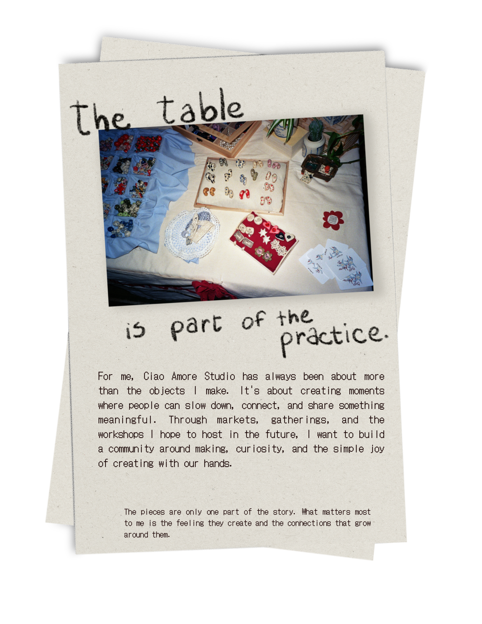 A collection of handmade jewelry, including rings and pins, displayed on fabric and in small boxes on a table, with potted plants in the background.
