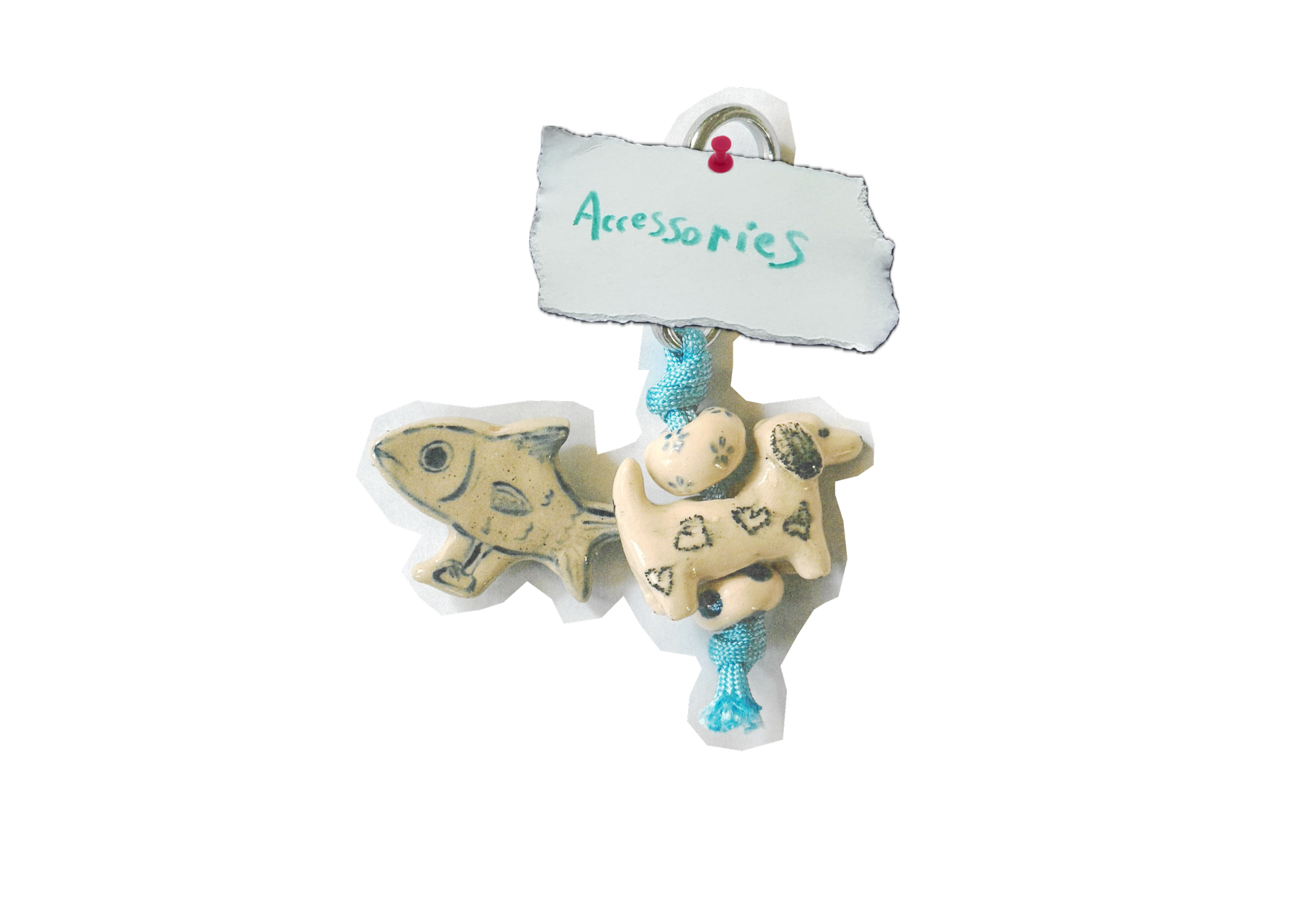 Decorative porcelain fish figurines with a torn note labeled 'Accessories' attached with a pushpin and a string.