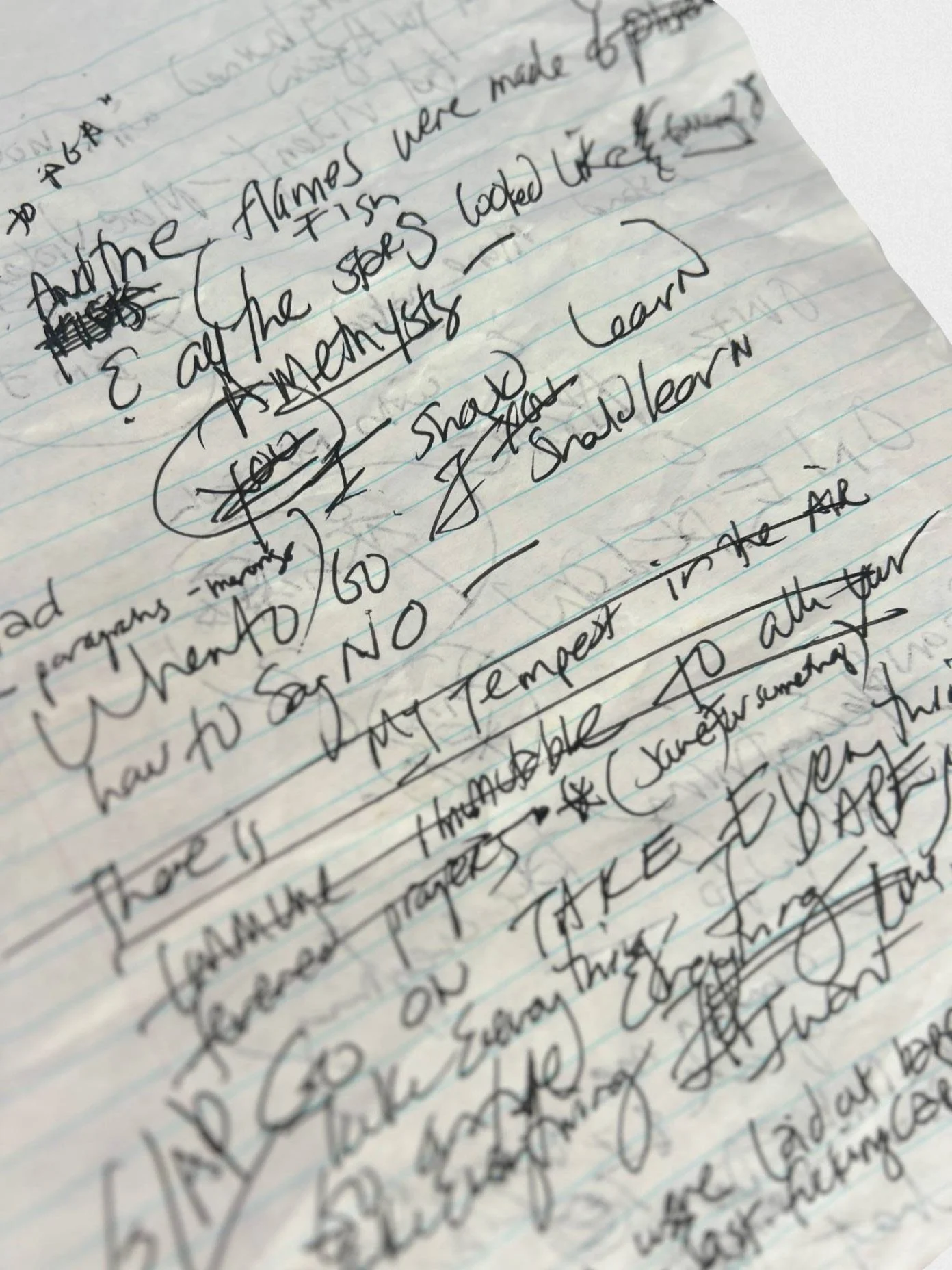 Close-up of handwritten notes on lined notebook paper, with ink scribbles and corrections, discussing topics related to the Alamo and other historical themes.