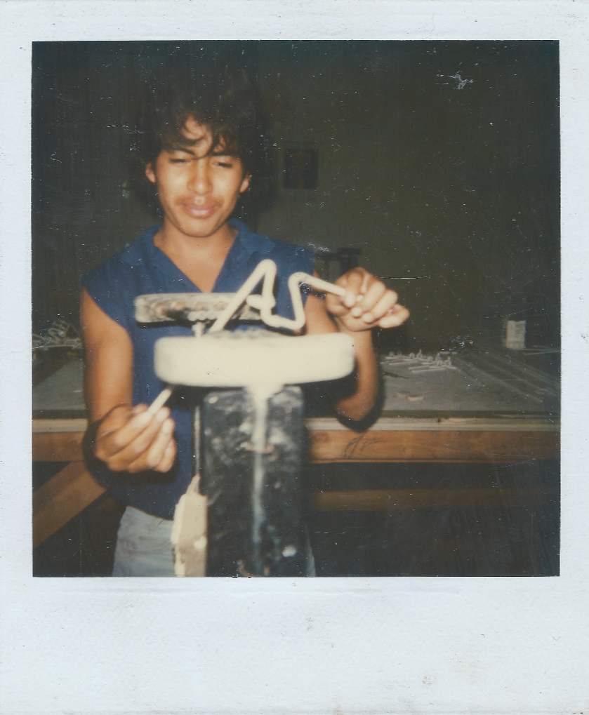 Child holding a birthday cake with number candles, including a star-shaped candle, at a birthday celebration.