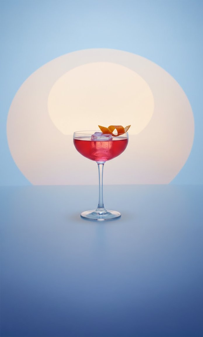 A cocktail glass with a red drink and ice cubes, garnished with orange peel, set against a stylized sunset backdrop.