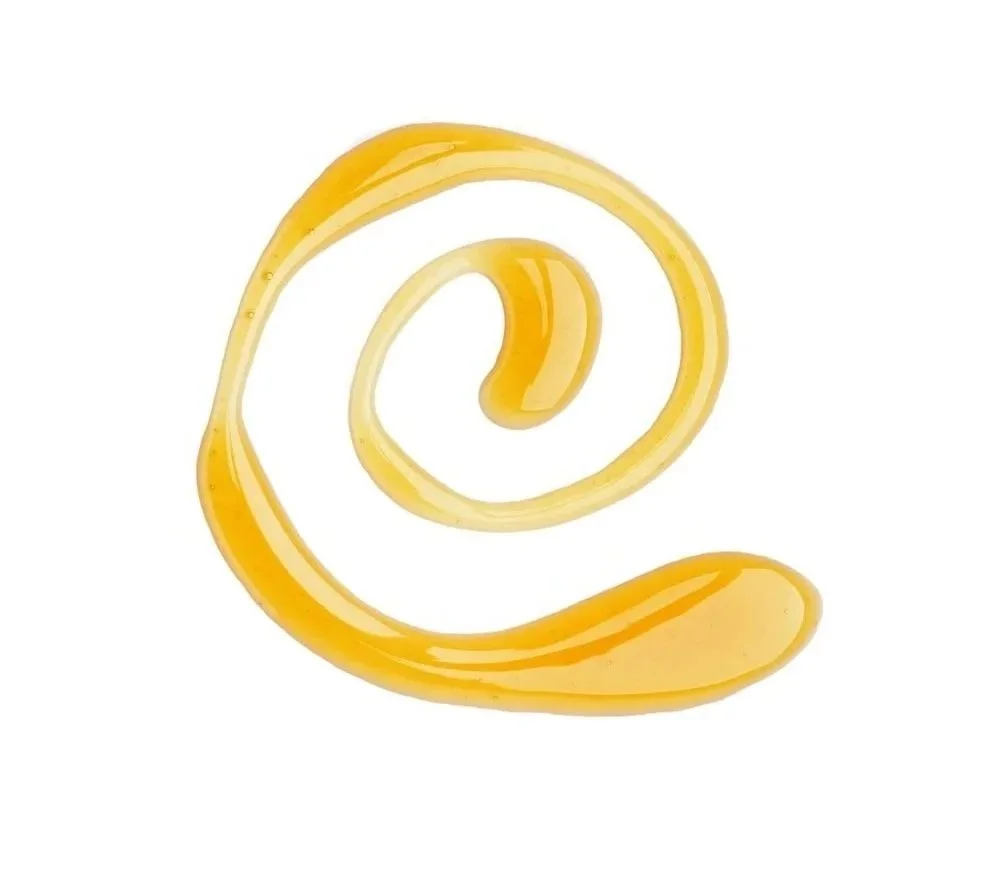 Un motif rappelant le sigle utilisé dans les adresses courriels dessiné avec du sirop d'érable  sur fond blanc.