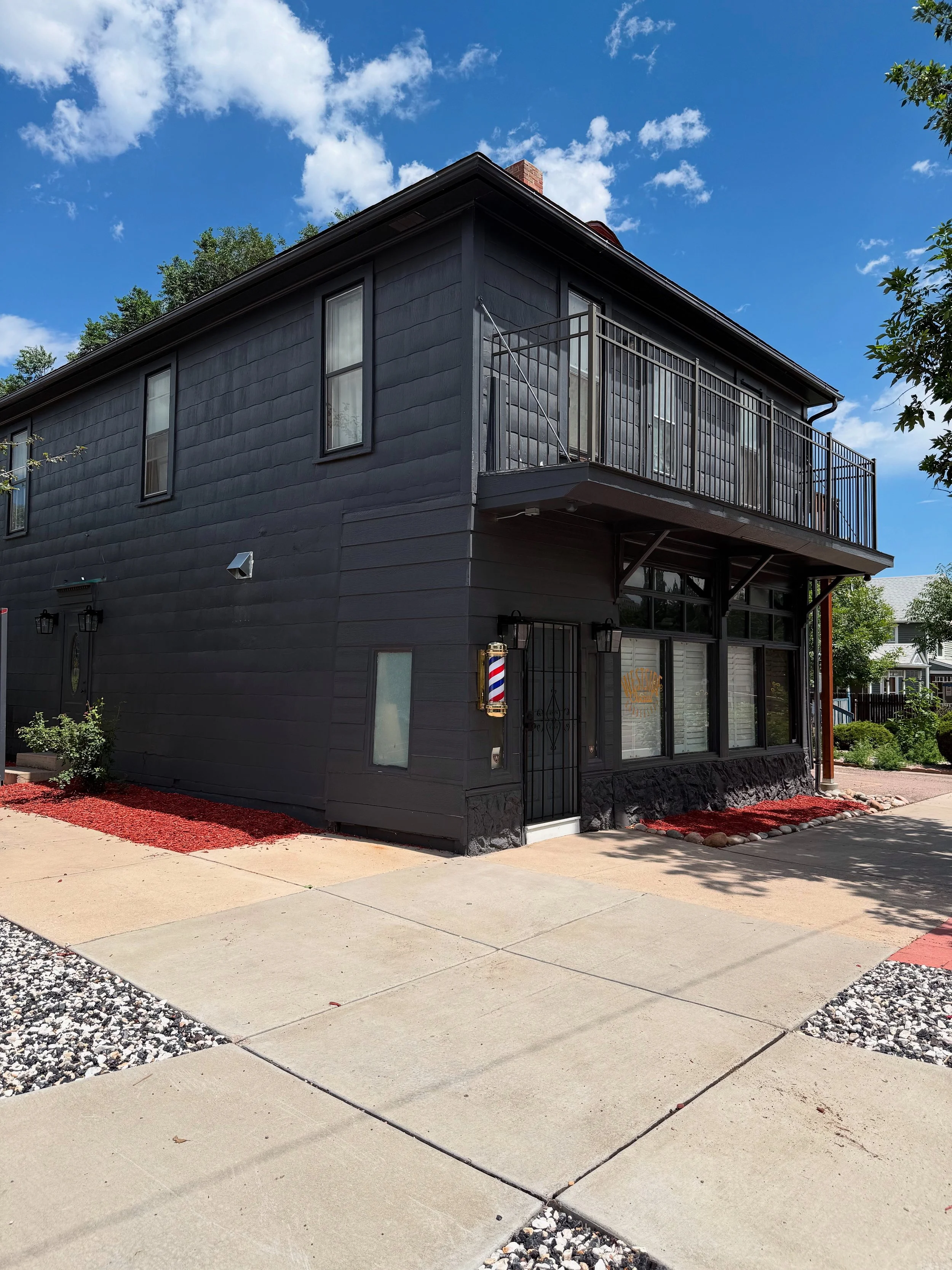 Exterior of Westside Social Barbershop at 432 W Bijou Street in Colorado Springs, featuring a classic barber pole at the entrance