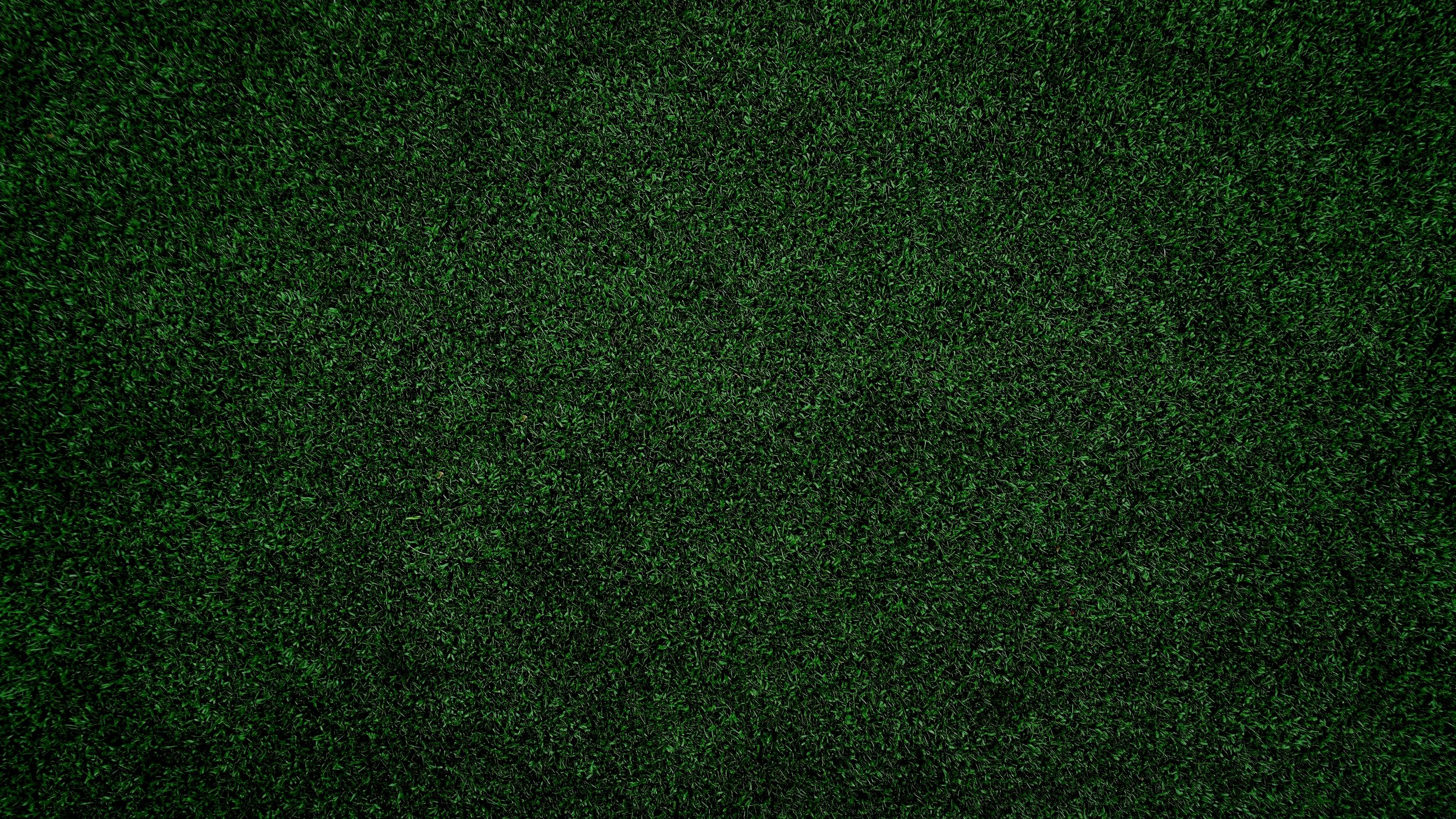 Close-up of a patch of green artificial grass with dense, short blades.