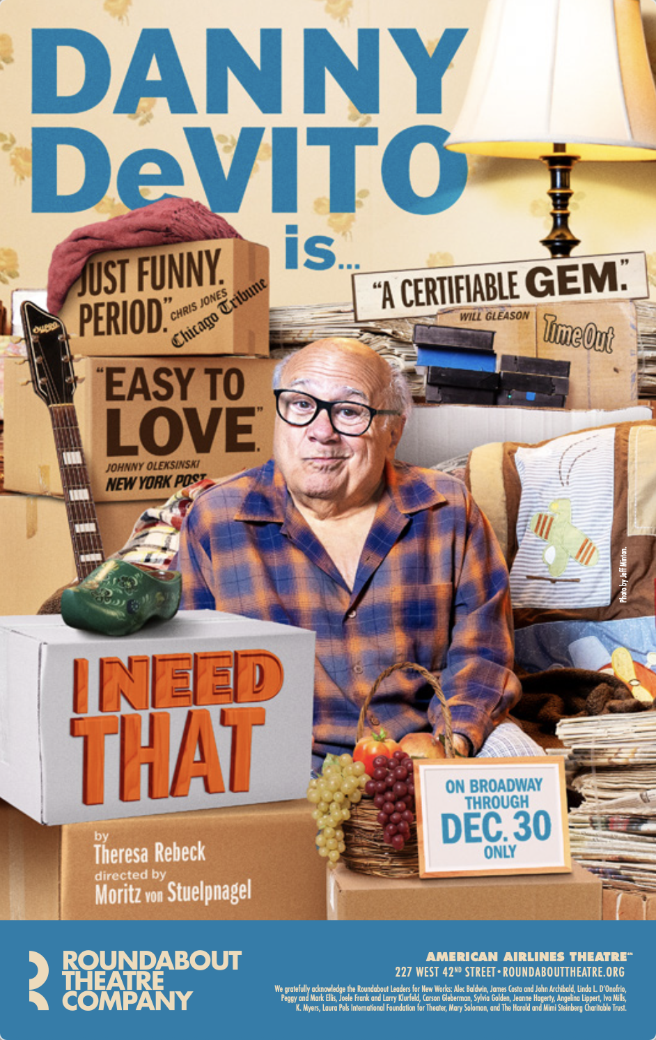 Promotional poster for Dany Devito's play, featuring Devito in a plaid shirt surrounded by boxes, quotes, props like a guitar and a block with 'I NEED THAT' written on it, and a sign indicating Broadway performances until December 30.