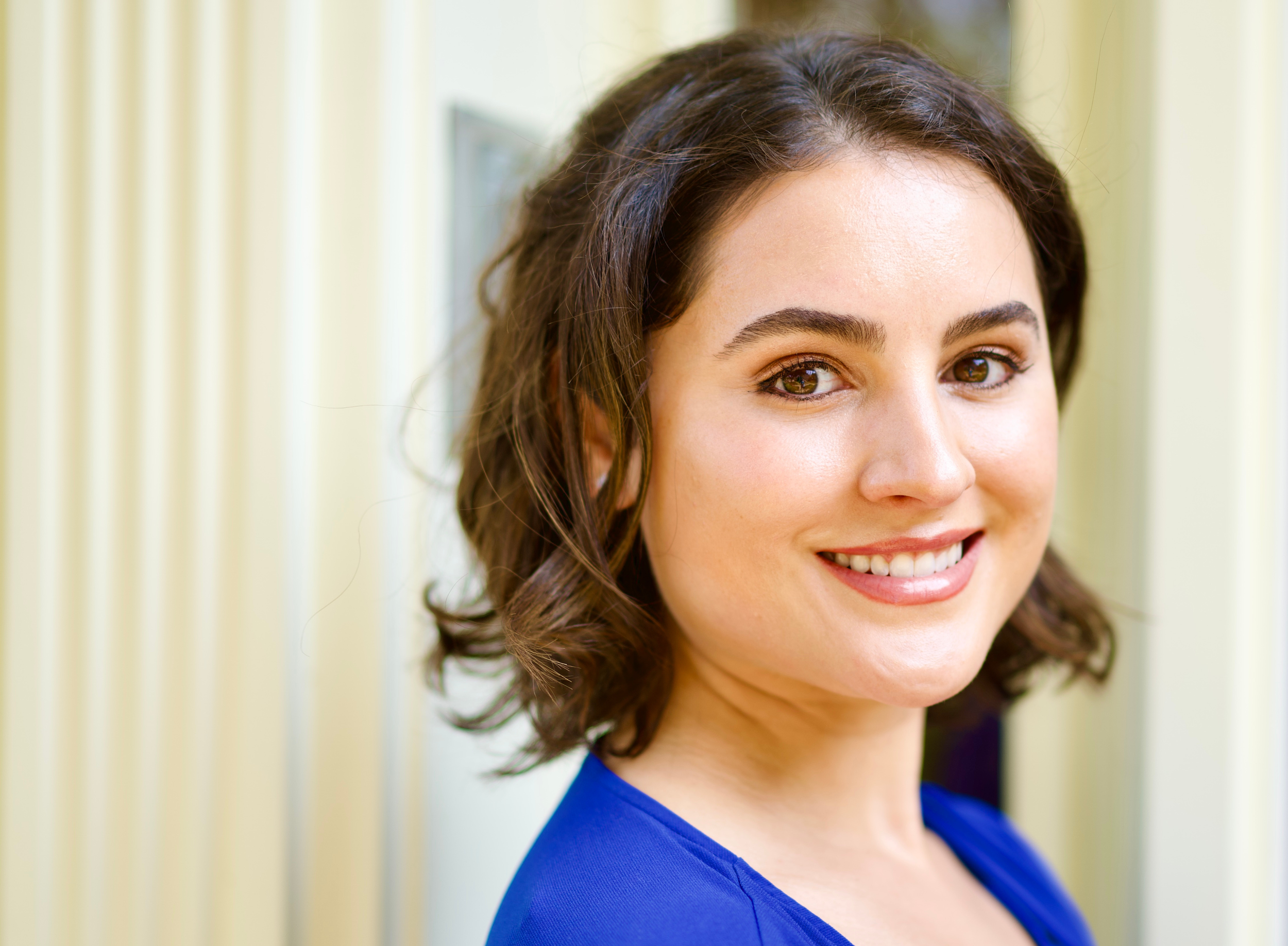 Olympia Georgeson, Attachment and Trauma-Informed Relationship Therapist, Coach & Educator, wearing a blue top.