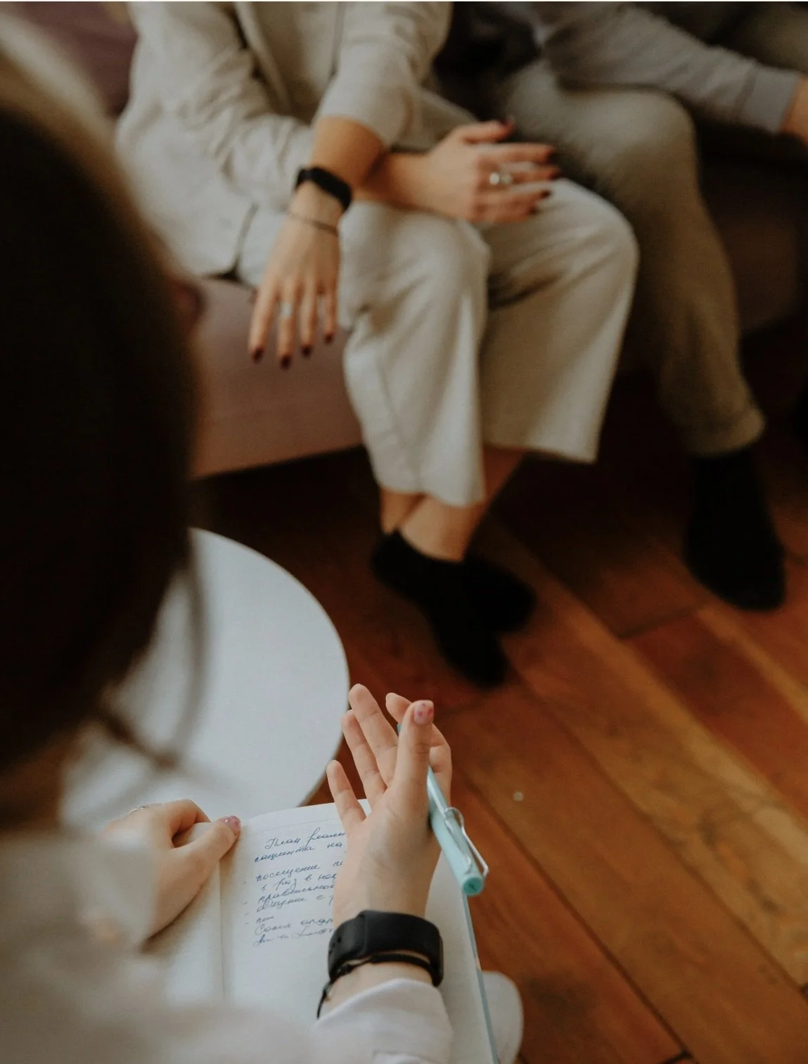 Client sitting on sofa as the therapist across from client takes an intake.