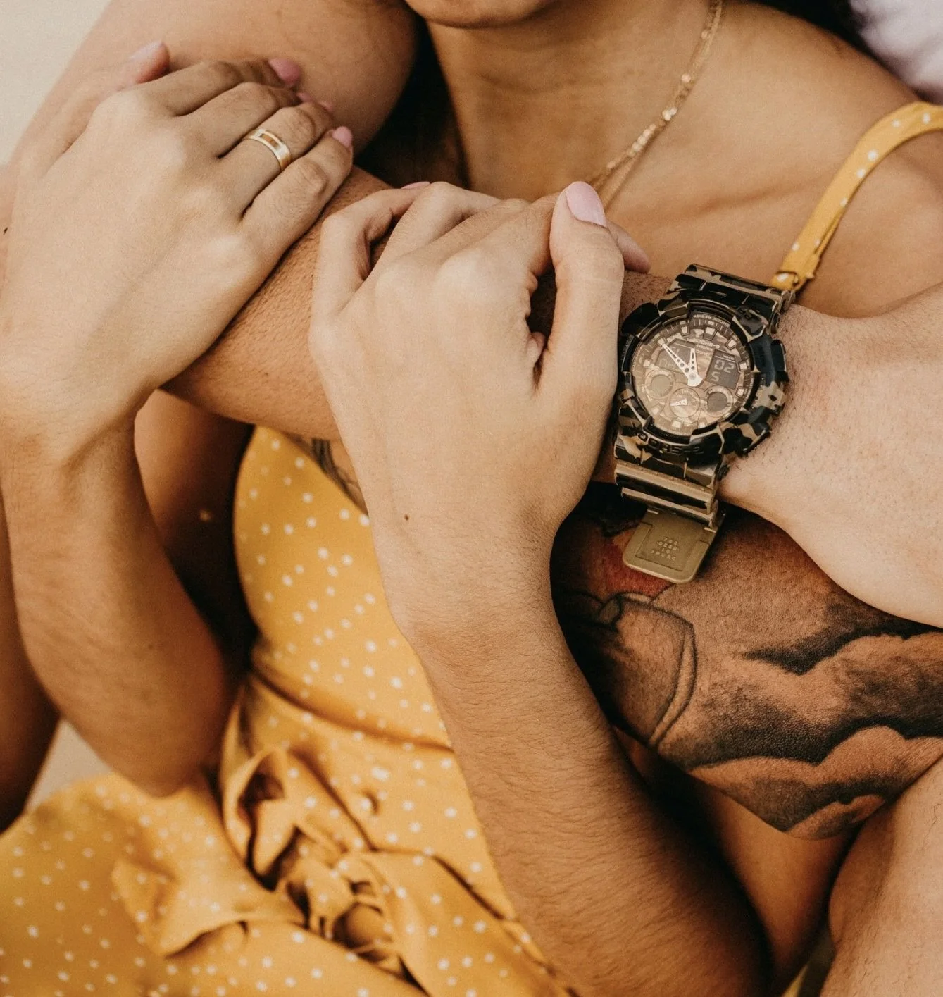 Close-up of a man holding a woman. She is trapped in his embrace.