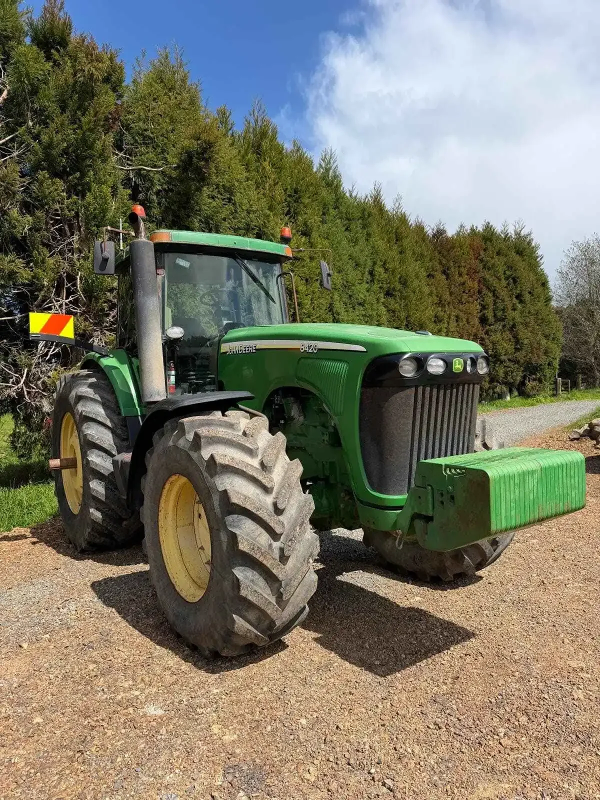 John Deere 8420 tractor front-right view showing front weights and enclosed cab