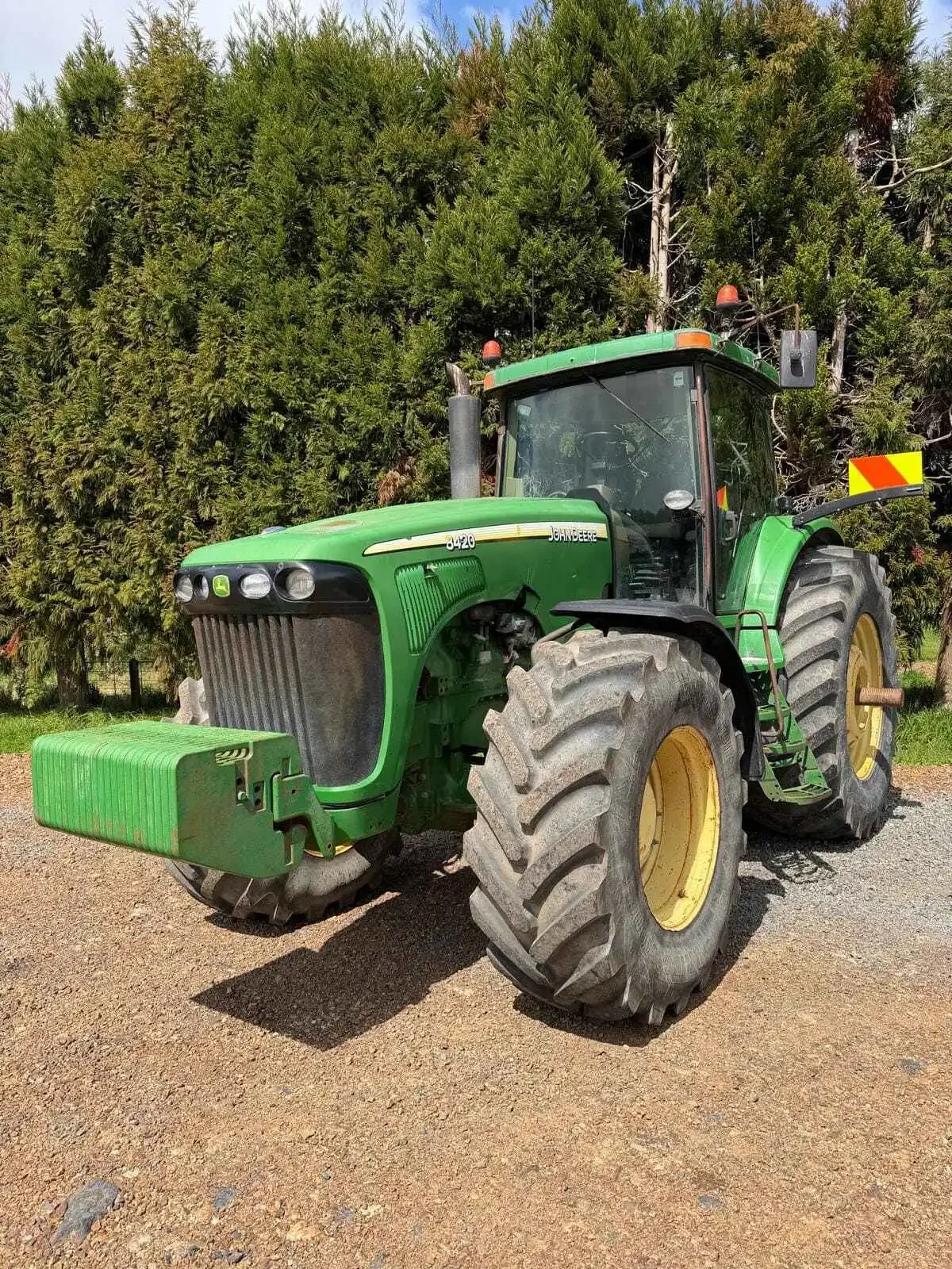 John Deere 8420 tractor front-left view with front weights and enclosed cab