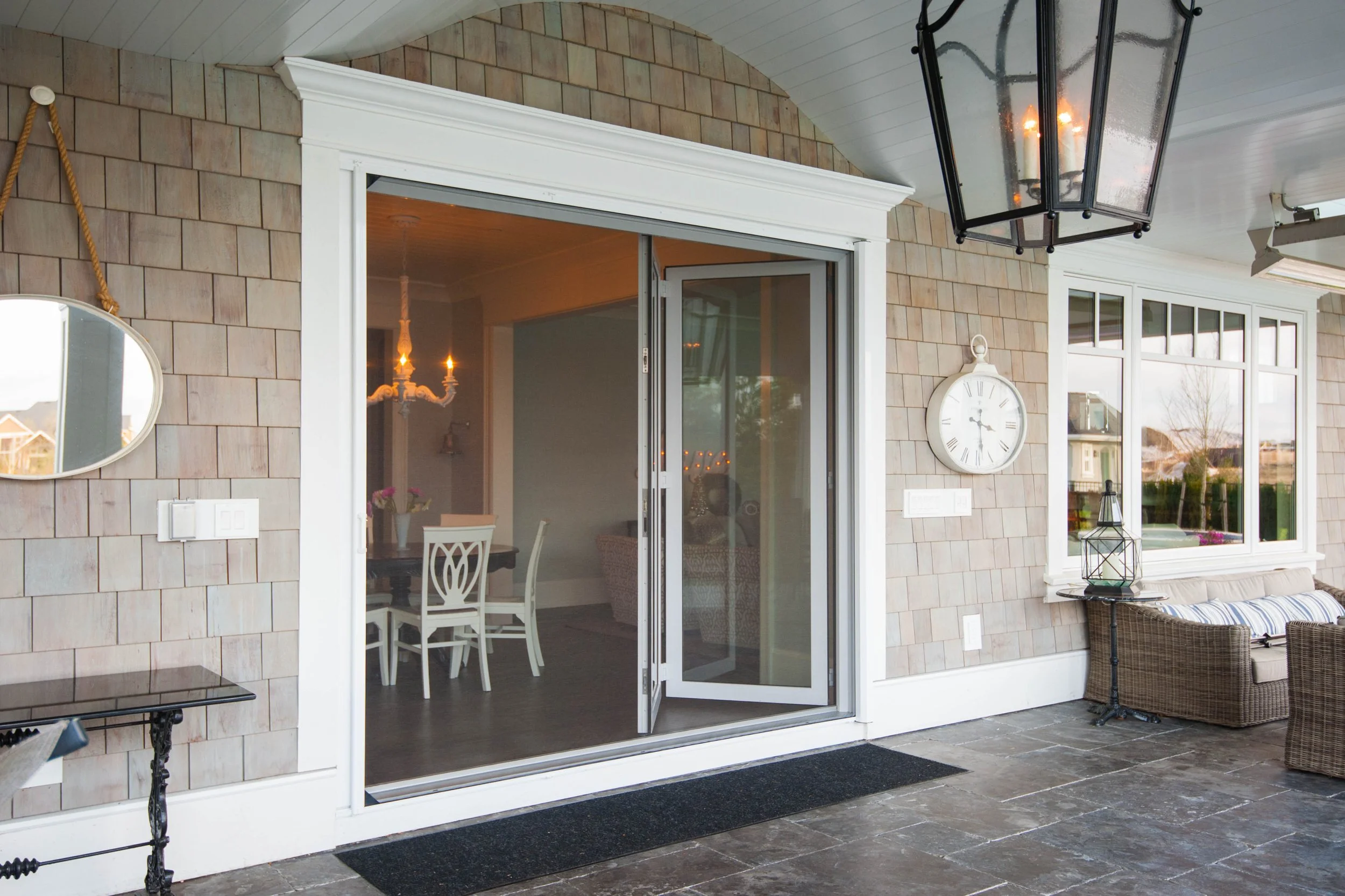 Phantom Oversized Retractable Wall Screen on a white Inward Folding Glass door System
