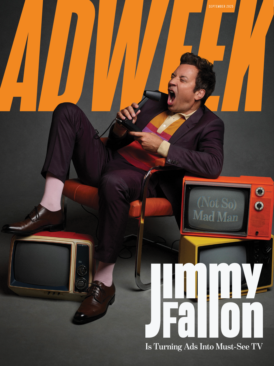 Magazine cover featuring Jimmy Fallon, seated on an orange chair with two vintage televisions, one with a screen displaying '(Not So) Mad Man,' and holding a rotary phone. Large orange text spells out 'ADVERTISE' in the background, with the headline 