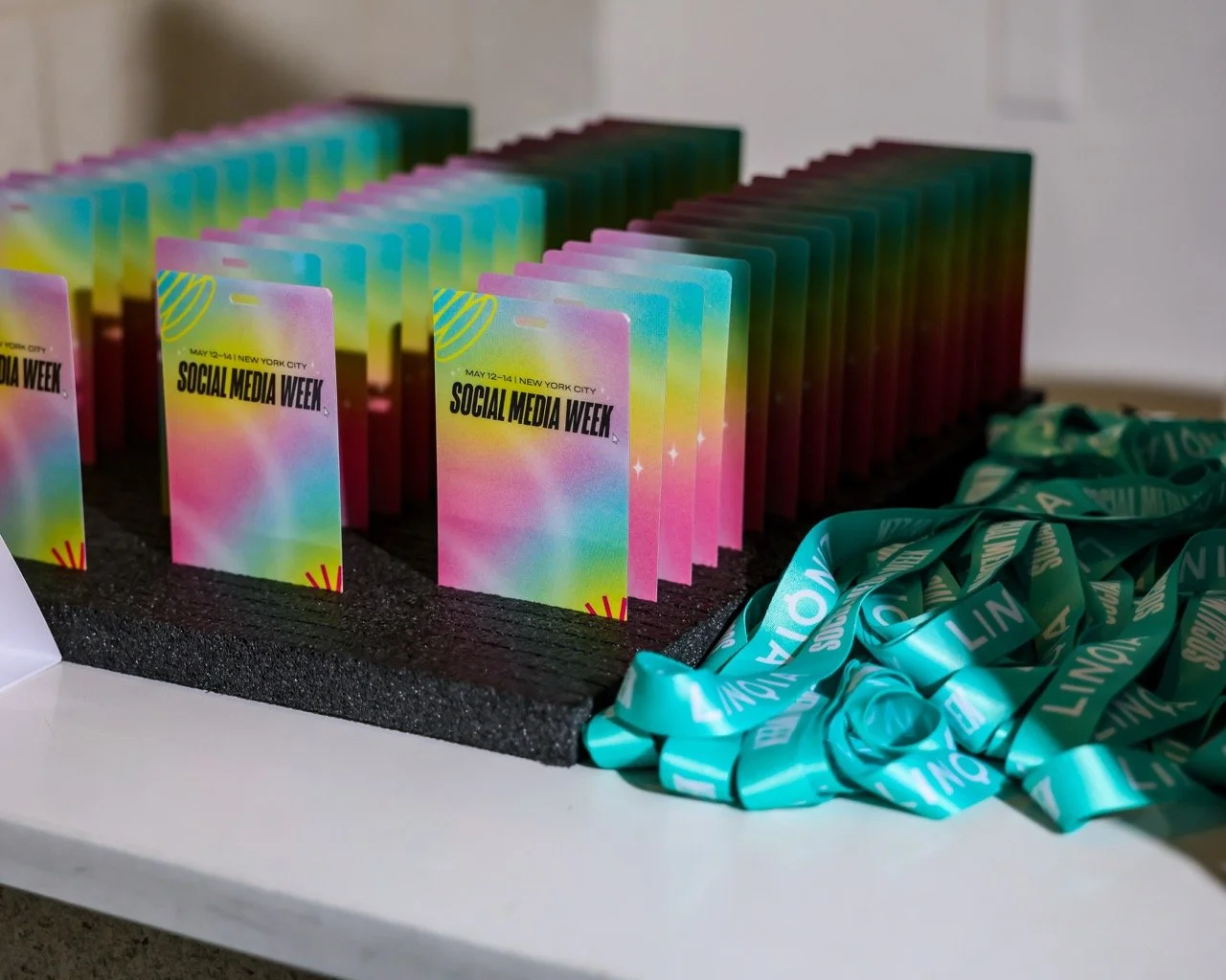 Colorful promotional cards and teal lanyards for Social Media Week in New York City.