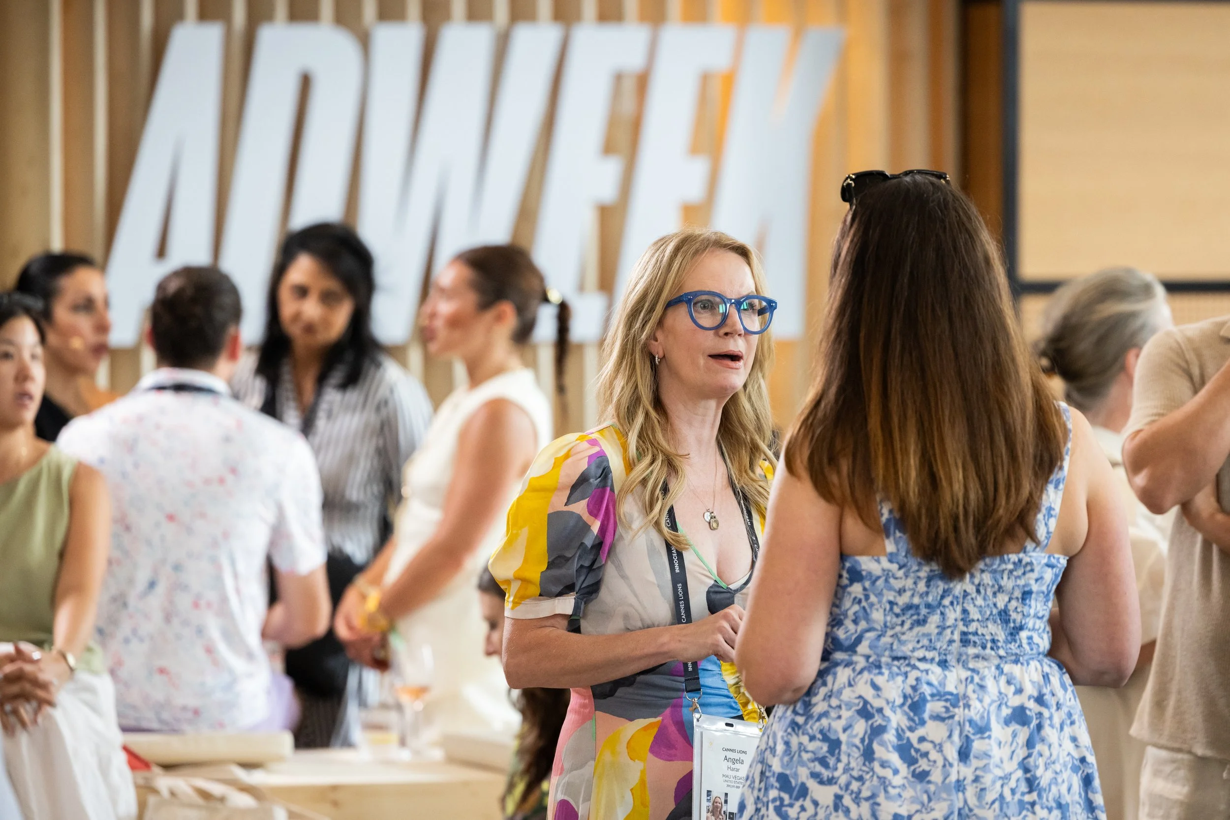 Group of women in conversation at a professional event, with large 'ADWEEK' sign in the background.