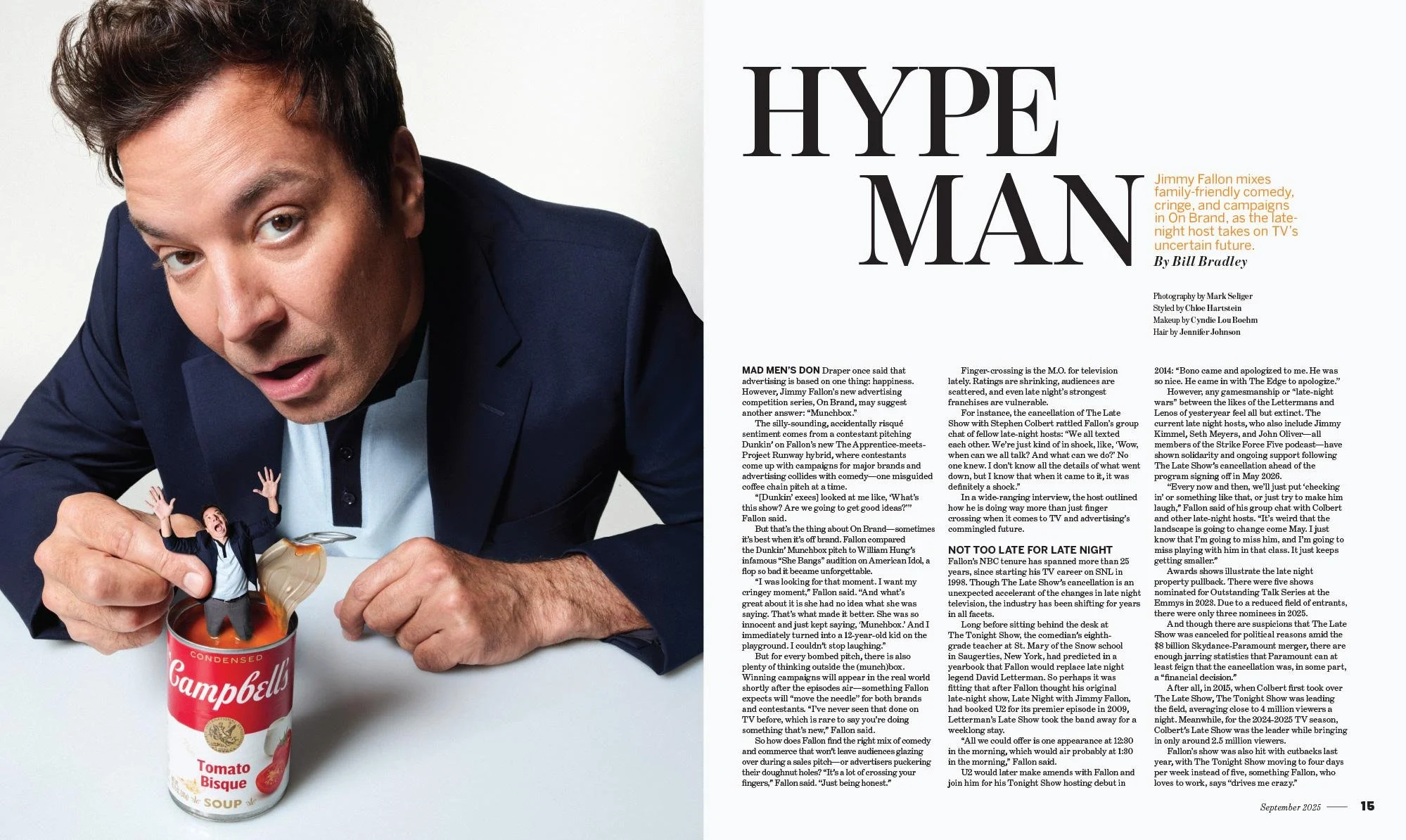 Photograph of a man in a navy blazer and light blue shirt leaning over a can of Campbell's Tomato Bisque Soup, with a tiny person in a suit and tie emerging from the can, appearing to be shouting.