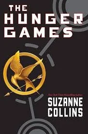 Cover of The Hunger Games book by Suzanne Collins, featuring a mockingjay pin with a gold finish.