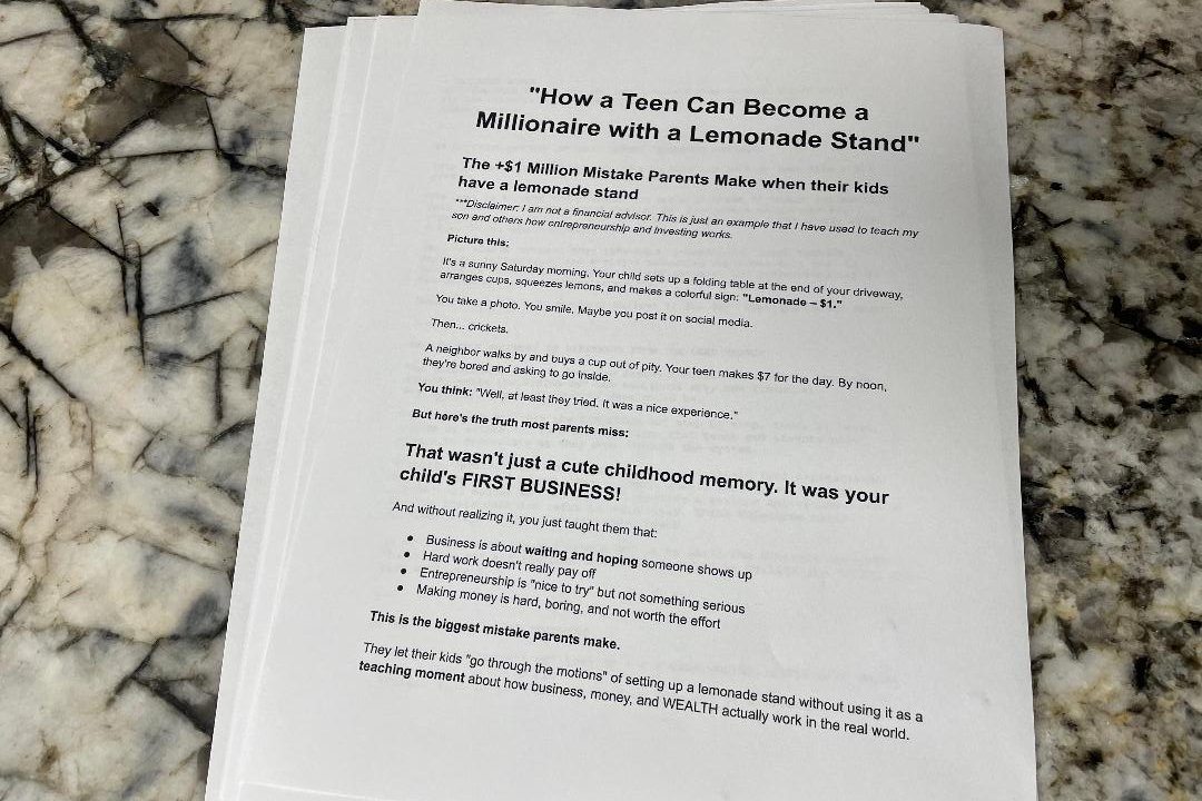 A printed article titled "How a Teen Can Become a Millionaire with a Lemonade Stand" is placed on a granite countertop.
