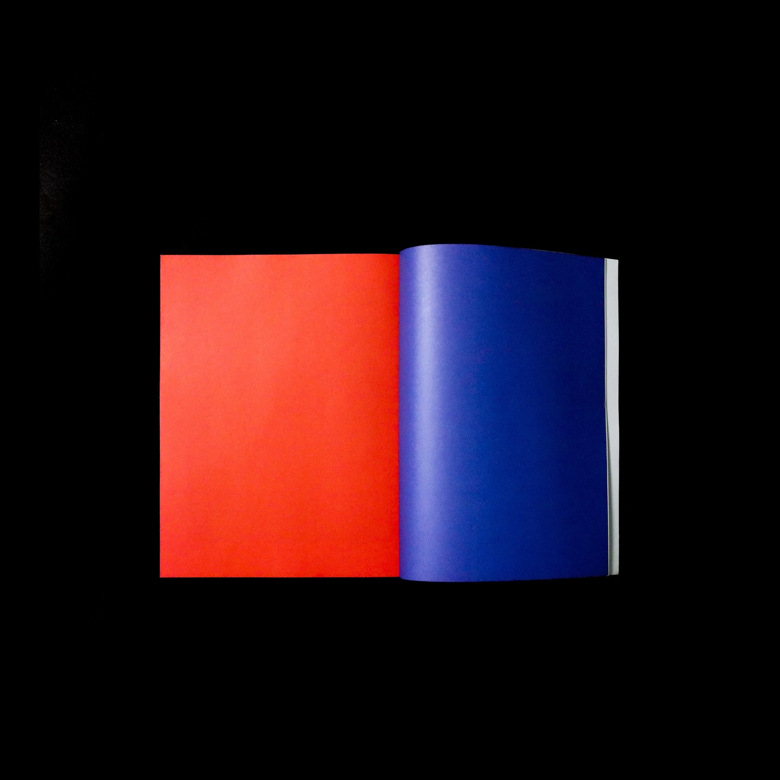 An open book with one red page and one blue page on a black background.